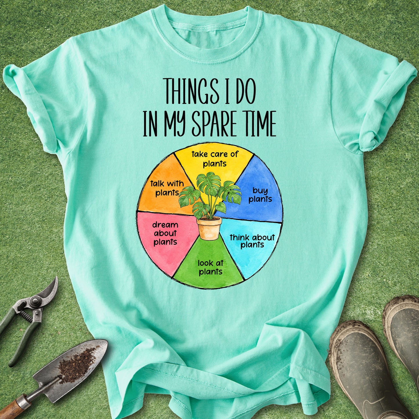 Colorful pie chart design reading "Things I Do in My Spare Time" with sections for buying, caring for, talking with, thinking about, looking at, and dreaming about plants, printed on a Comfort Colors 1717 t-shirt.