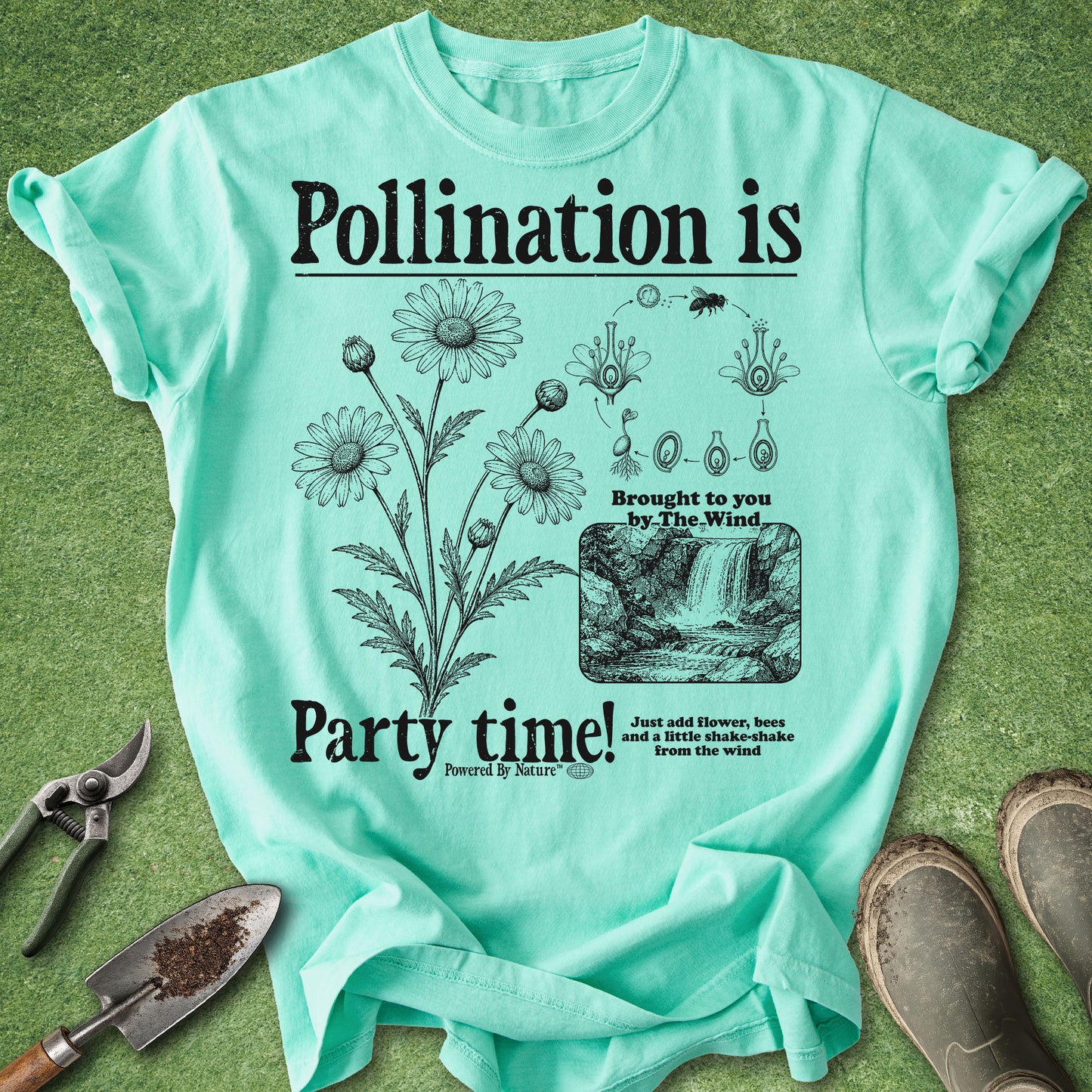 Mint green t-shirt with botanical design and text on a grass background