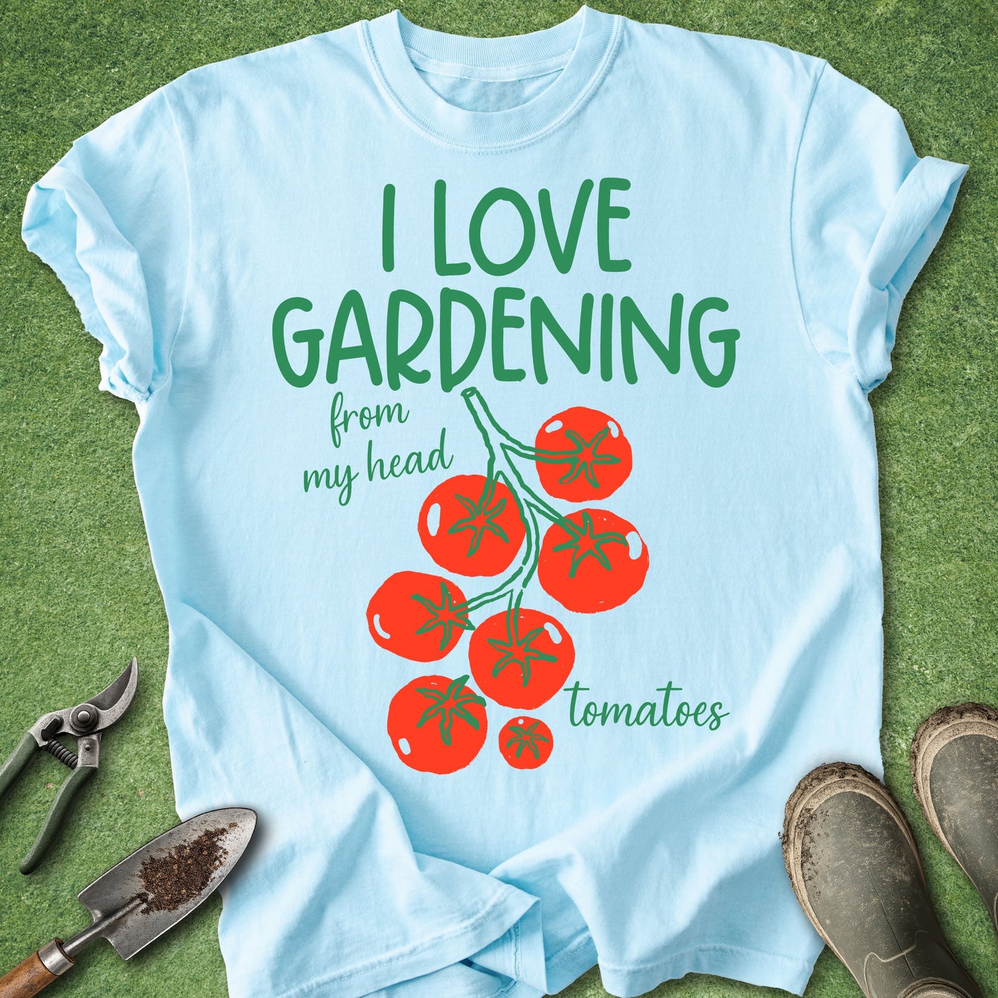 Light blue t-shirt with 'I love gardening from my head tomatoes' text and tomato graphics on a grass background.
