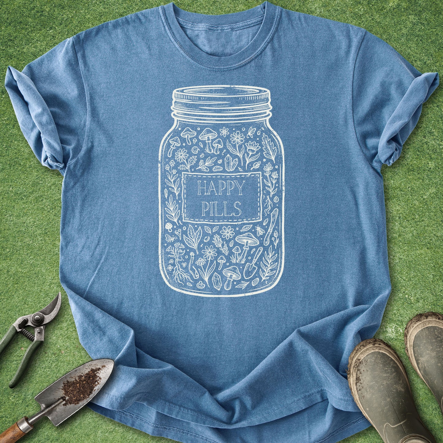 Blue t-shirt with 'Happy Pills' jar design on a green grass background