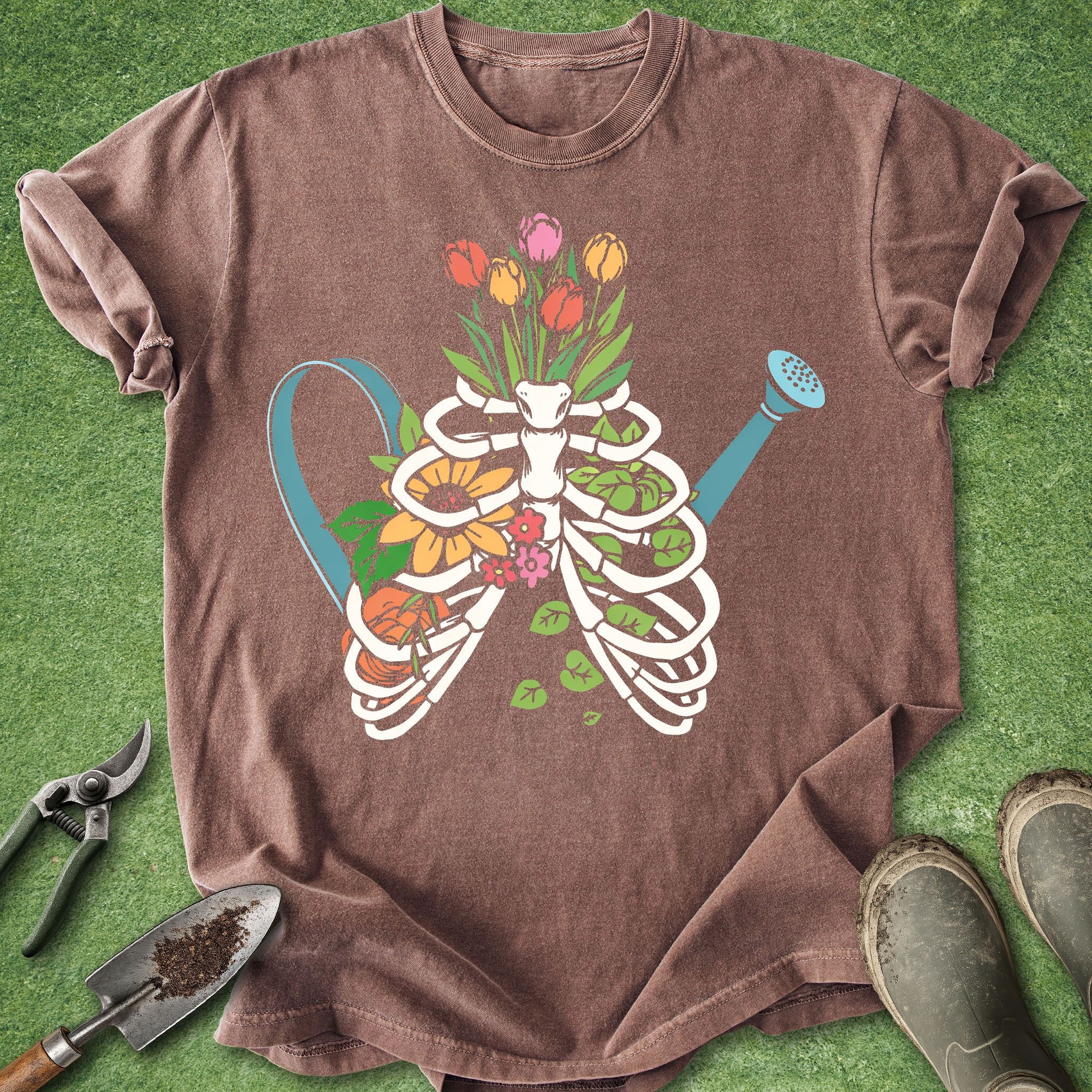 Brown t-shirt with a skeleton and floral design on a green grass background