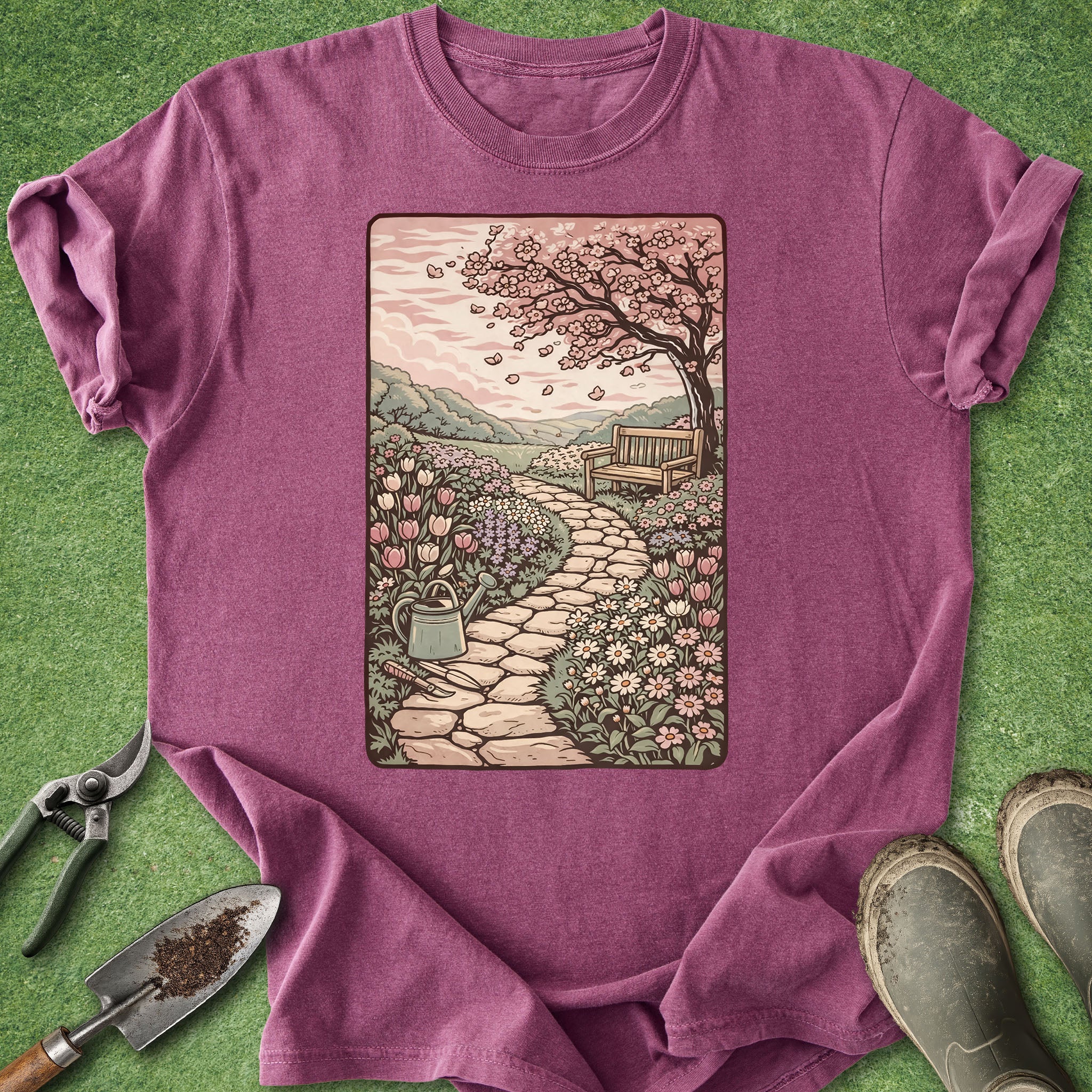 Purple t-shirt with a garden scene graphic on a grass background
