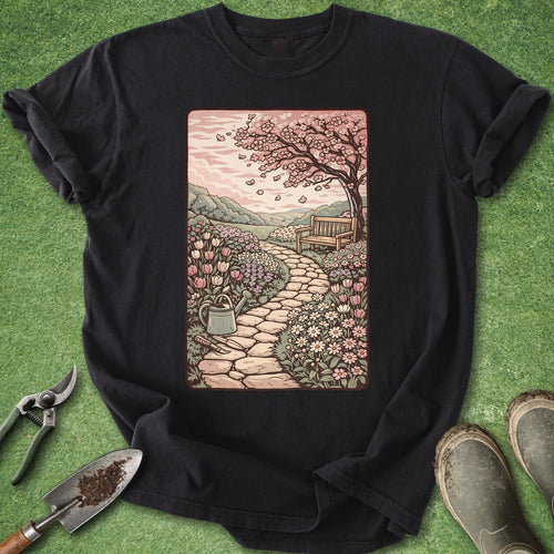Black t-shirt with a garden scene design on a green grass background
