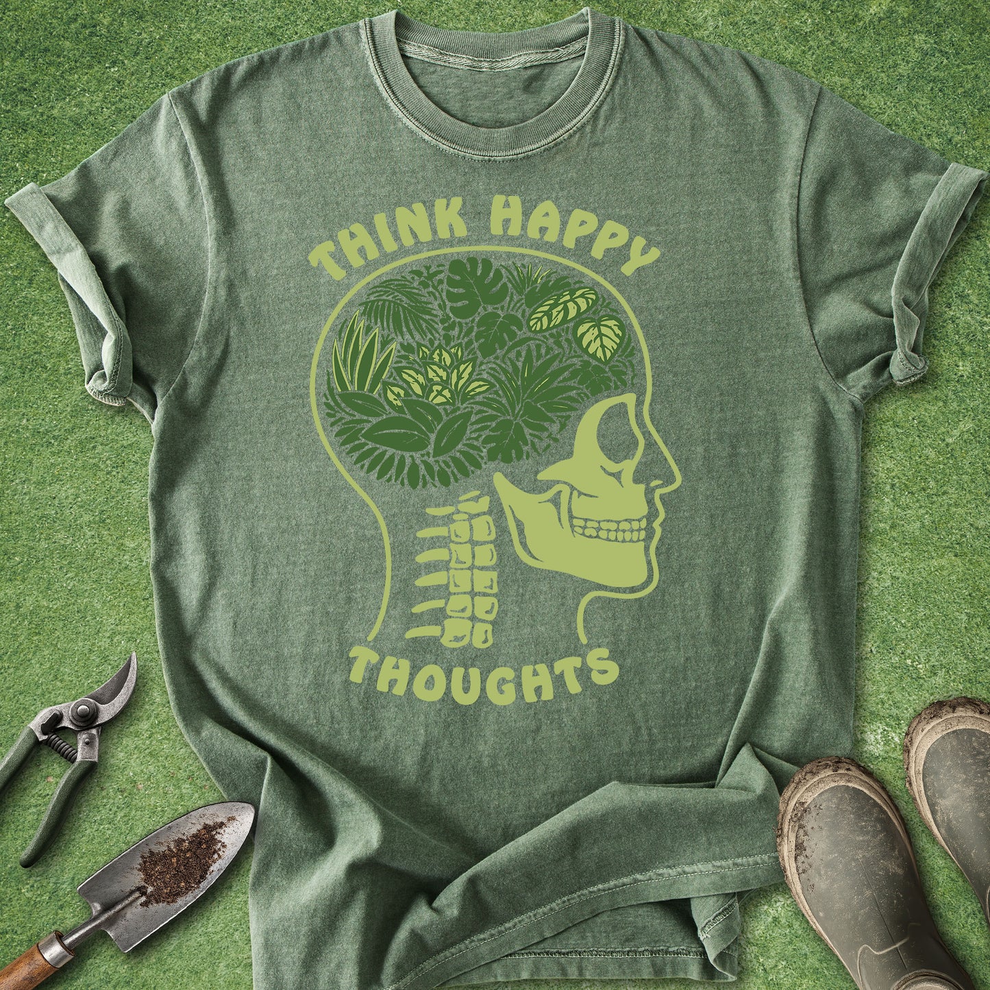 Green t-shirt with skull and leaves design on a grassy background