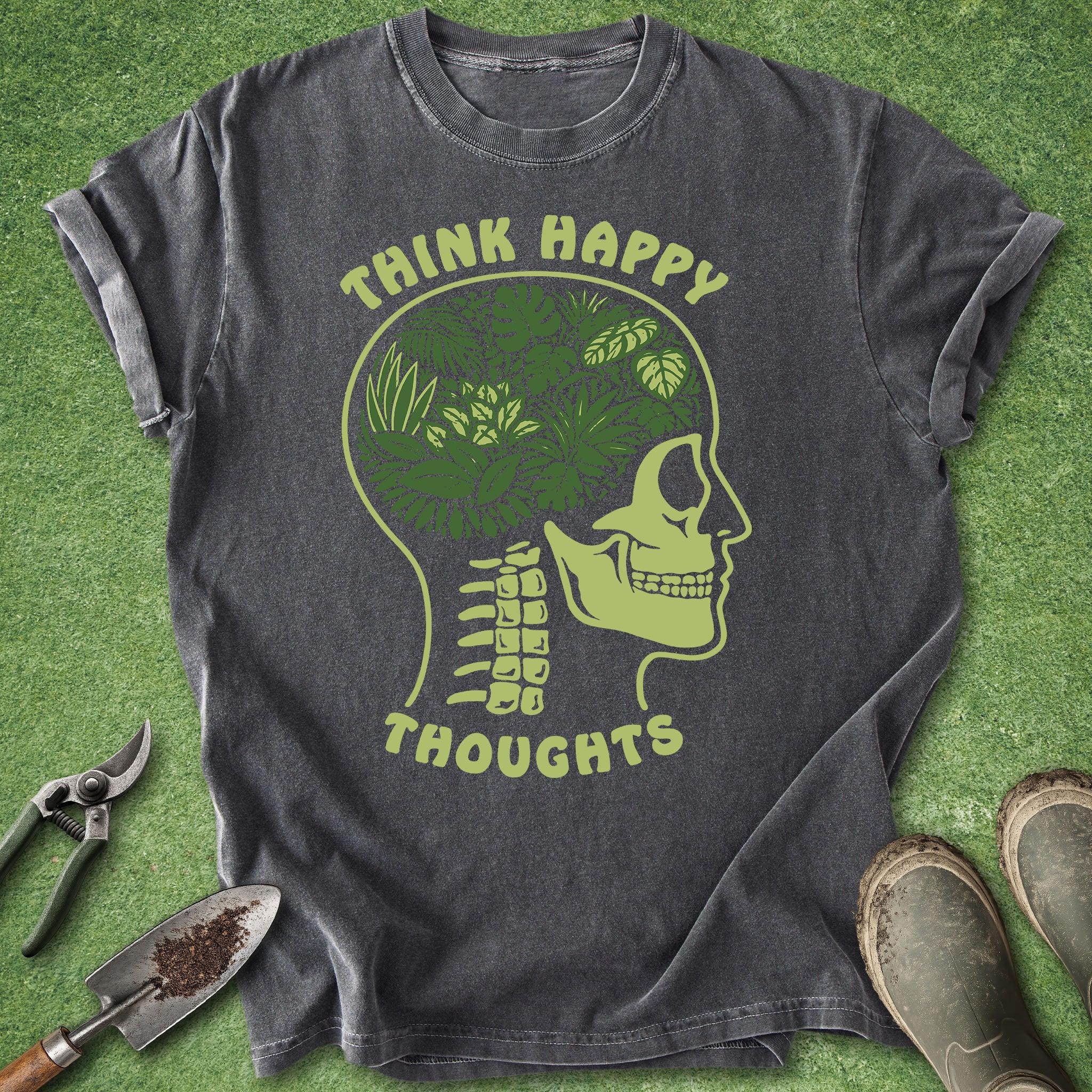 Gray t-shirt with green graphic and 'Think Happy Thoughts' text on a grass background