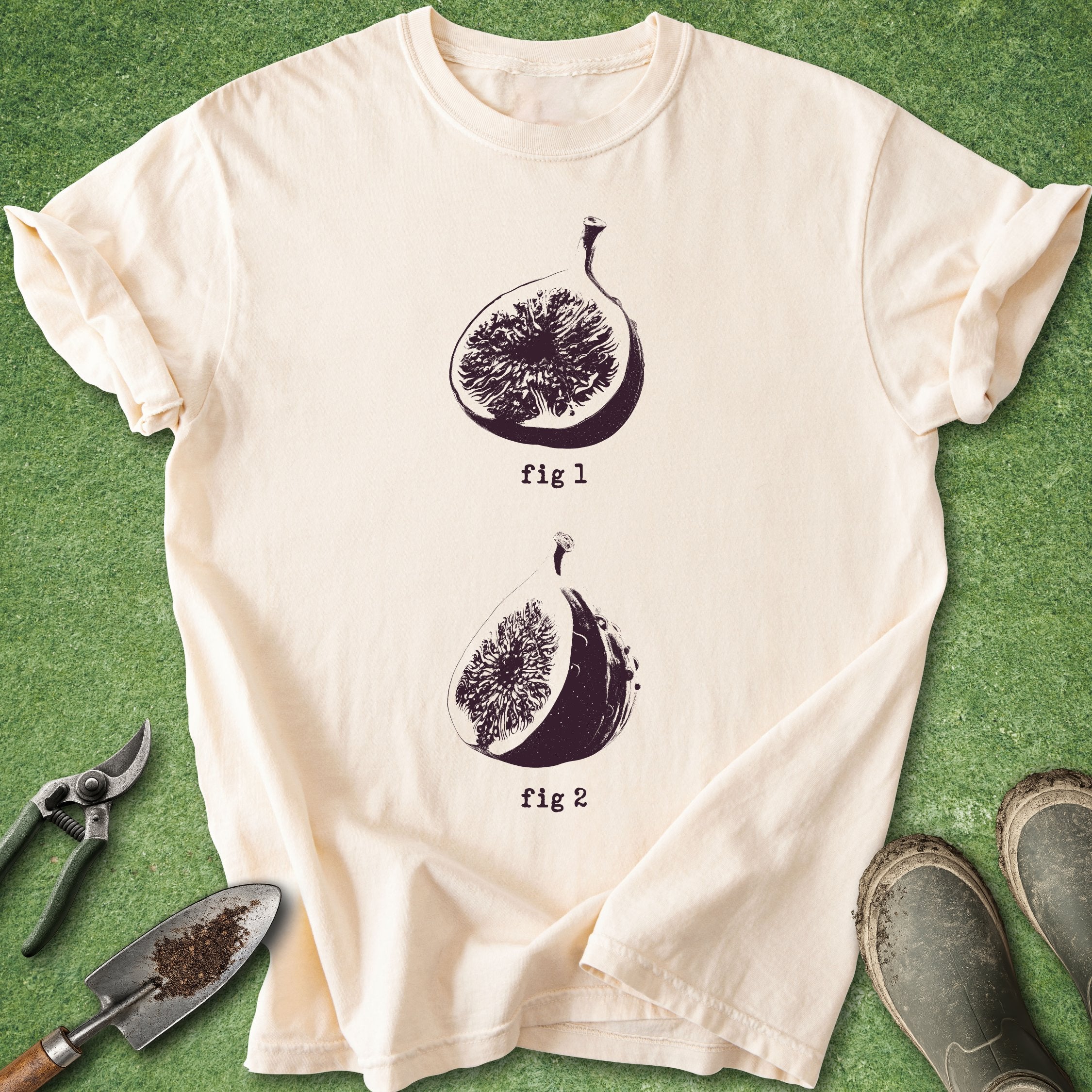 Beige t-shirt with fig illustrations on a green surface with gardening tools.