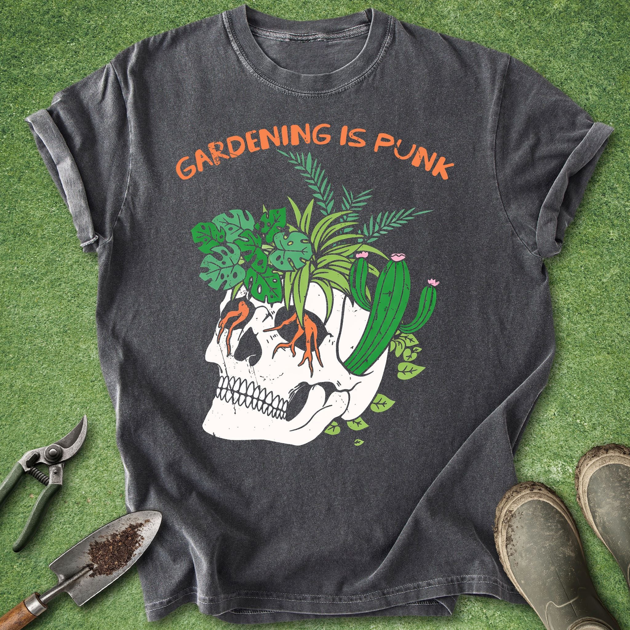 Gray t-shirt with skull and plants design on a grass background