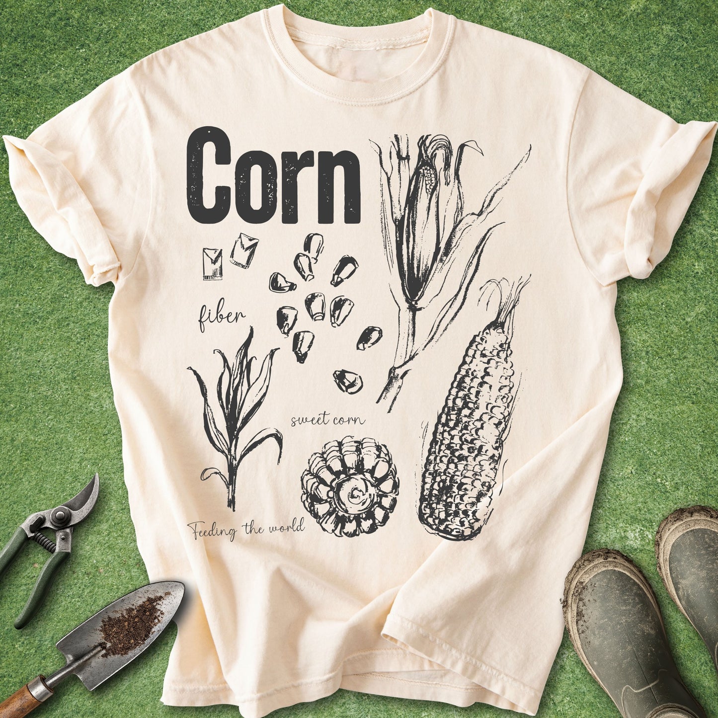 Beige t-shirt with corn illustration and text on a green background