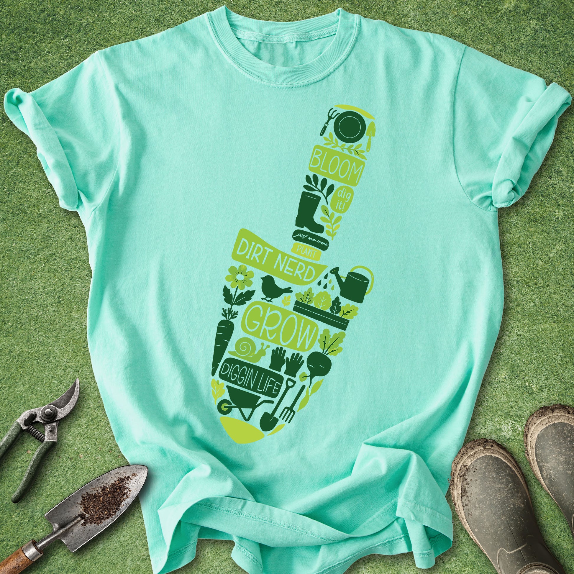 Mint green t-shirt with gardening-themed design on a grass background