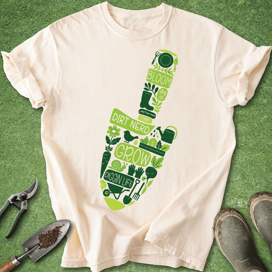 Gardening trowel graphic t-shirt with green gardening icons, vegetables, tools, and plant lover phrases on ivory shirt