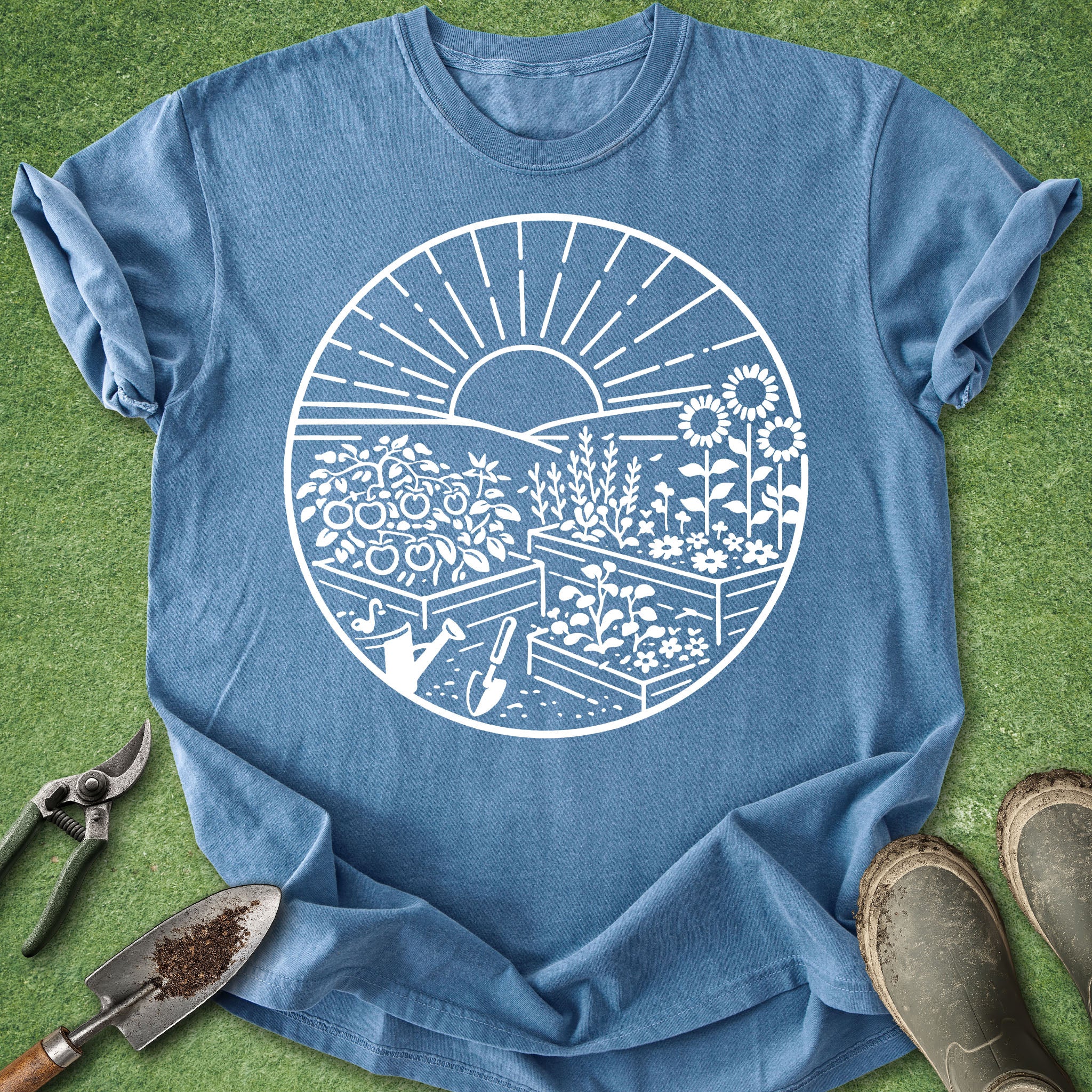 Blue t-shirt with white garden graphic on a green grass background