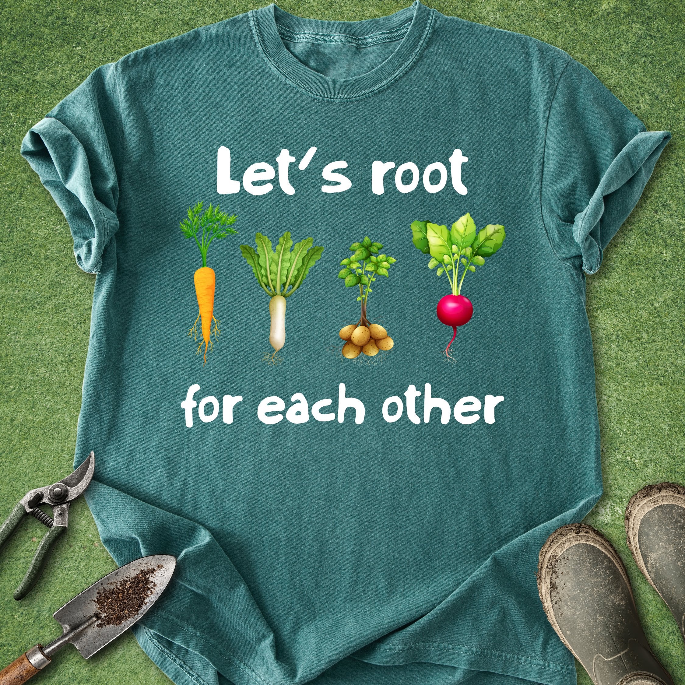 Teal t-shirt with gardening-themed design and tools on a grass background