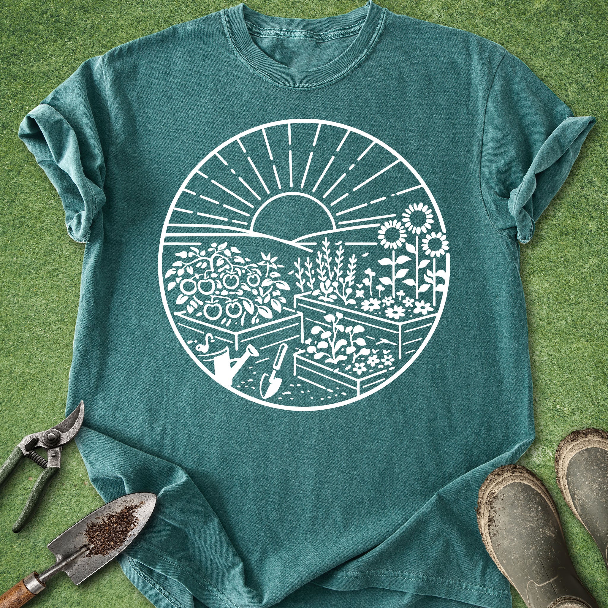 Teal t-shirt with white garden graphic on a grass background