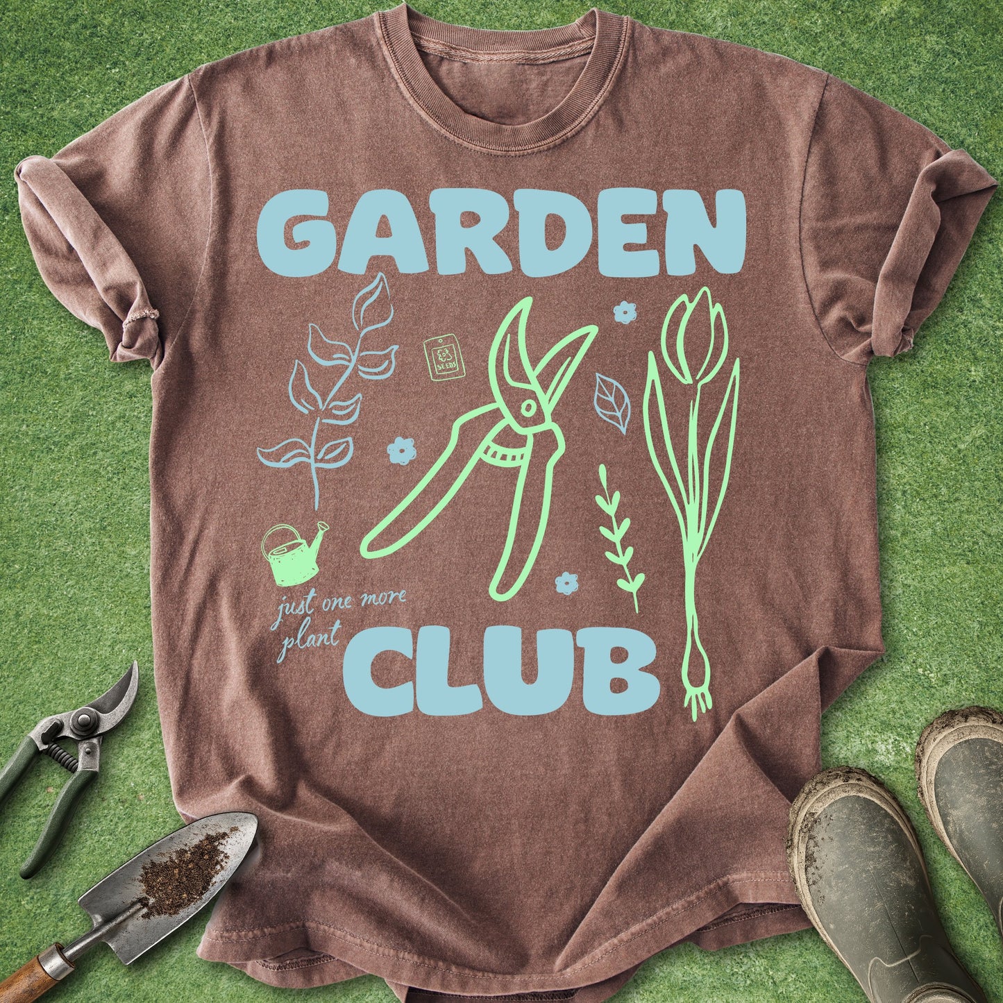Brown t-shirt with 'Garden Club' design on a green grass background