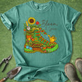 Teal t-shirt with a colorful boot graphic and 'Bloom & Grow' text on a green background.