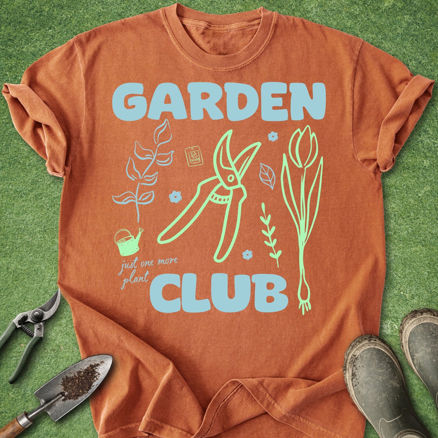 Orange t-shirt with 'Garden Club' design on a grass background