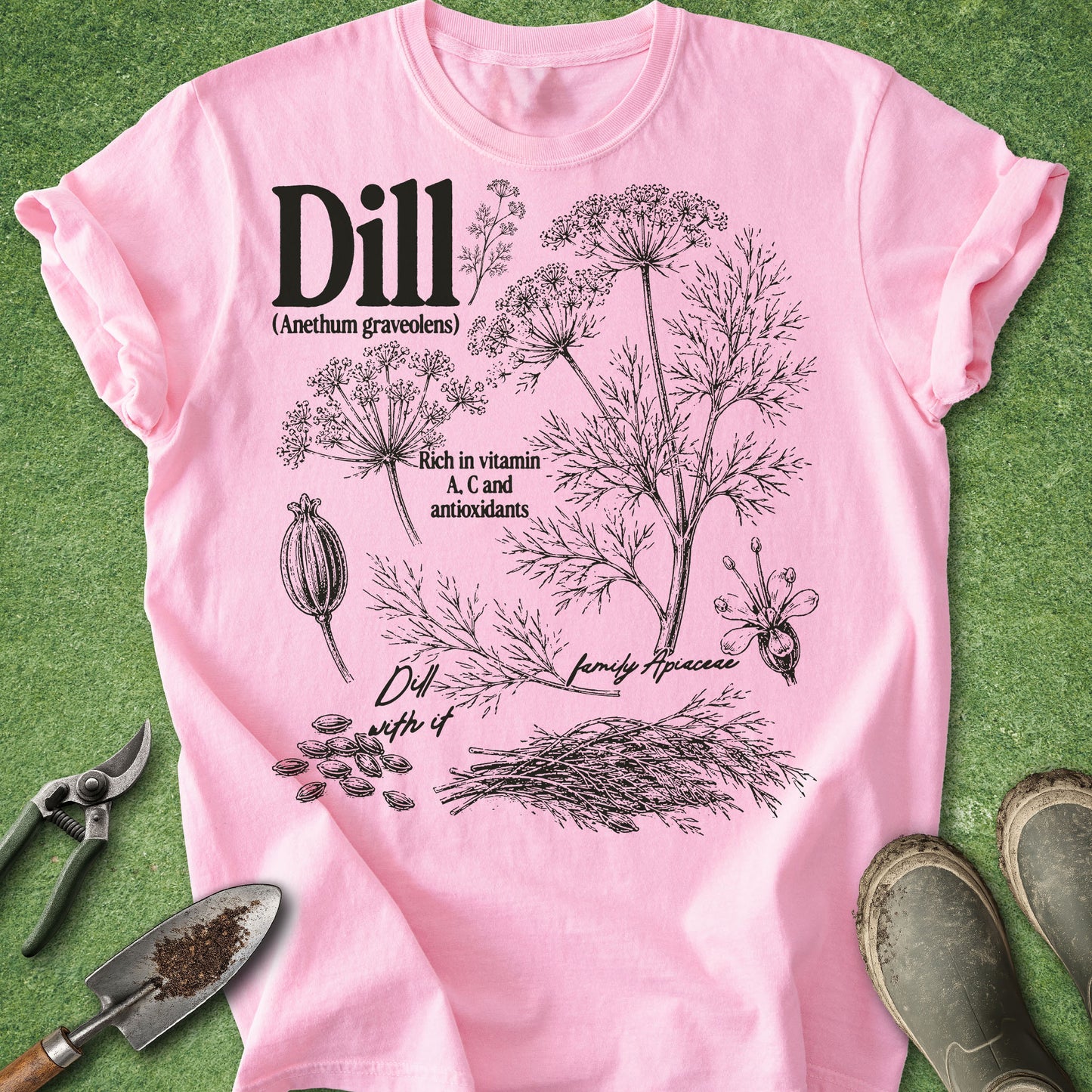 Pink t-shirt with dill plant illustration and text on a green background