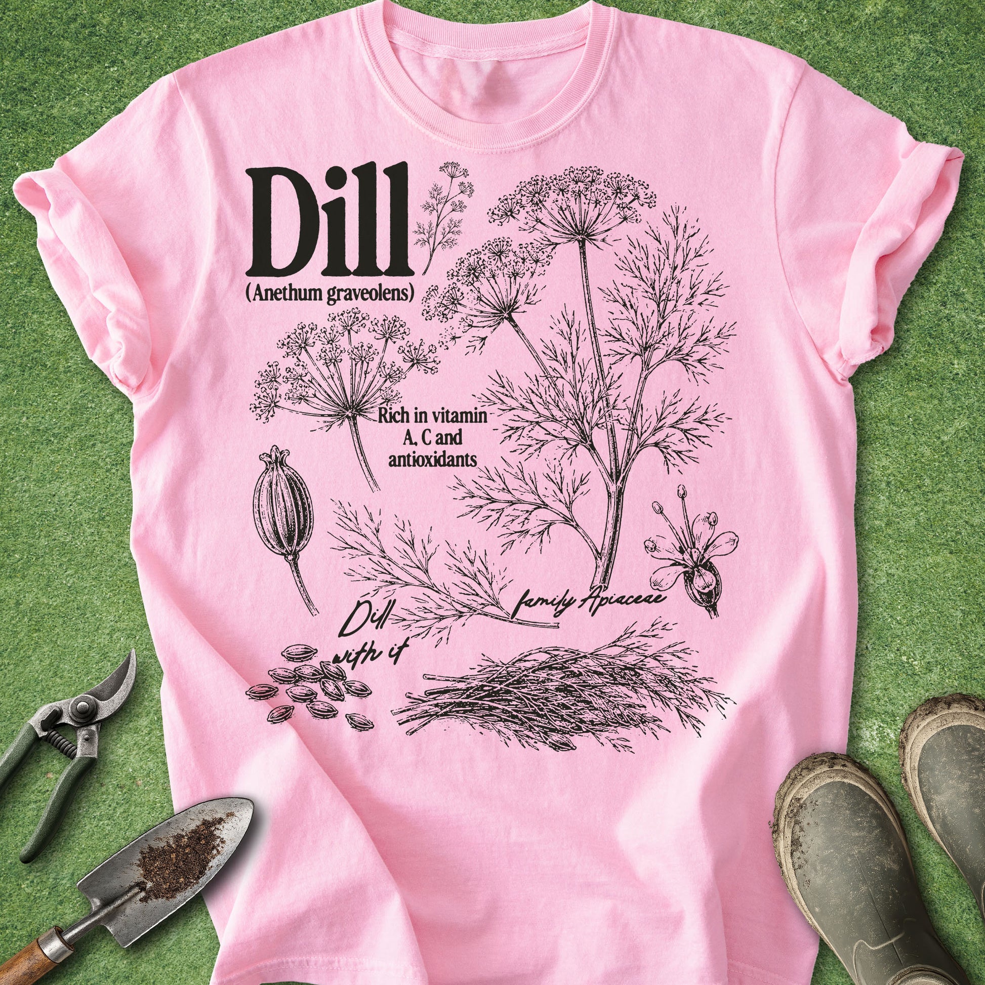 Pink t-shirt with dill plant illustration and text on a green background