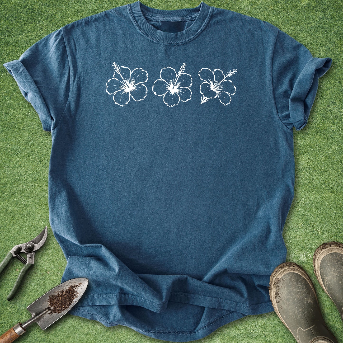 Midnight blue Comfort Colors t-shirt featuring three distressed white hibiscus flowers arranged across the upper chest.