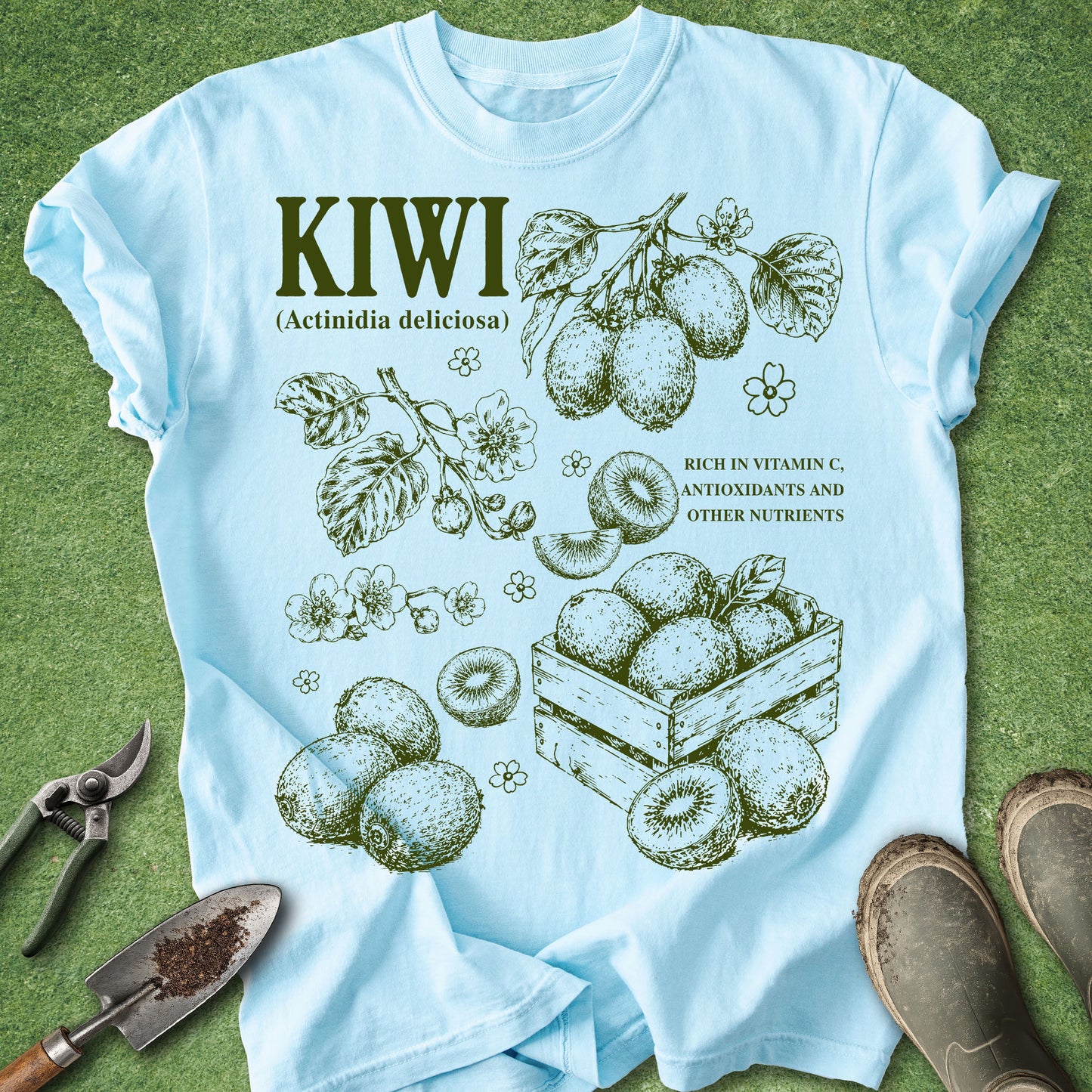 Light blue t-shirt with kiwi illustration and text on a green grass background