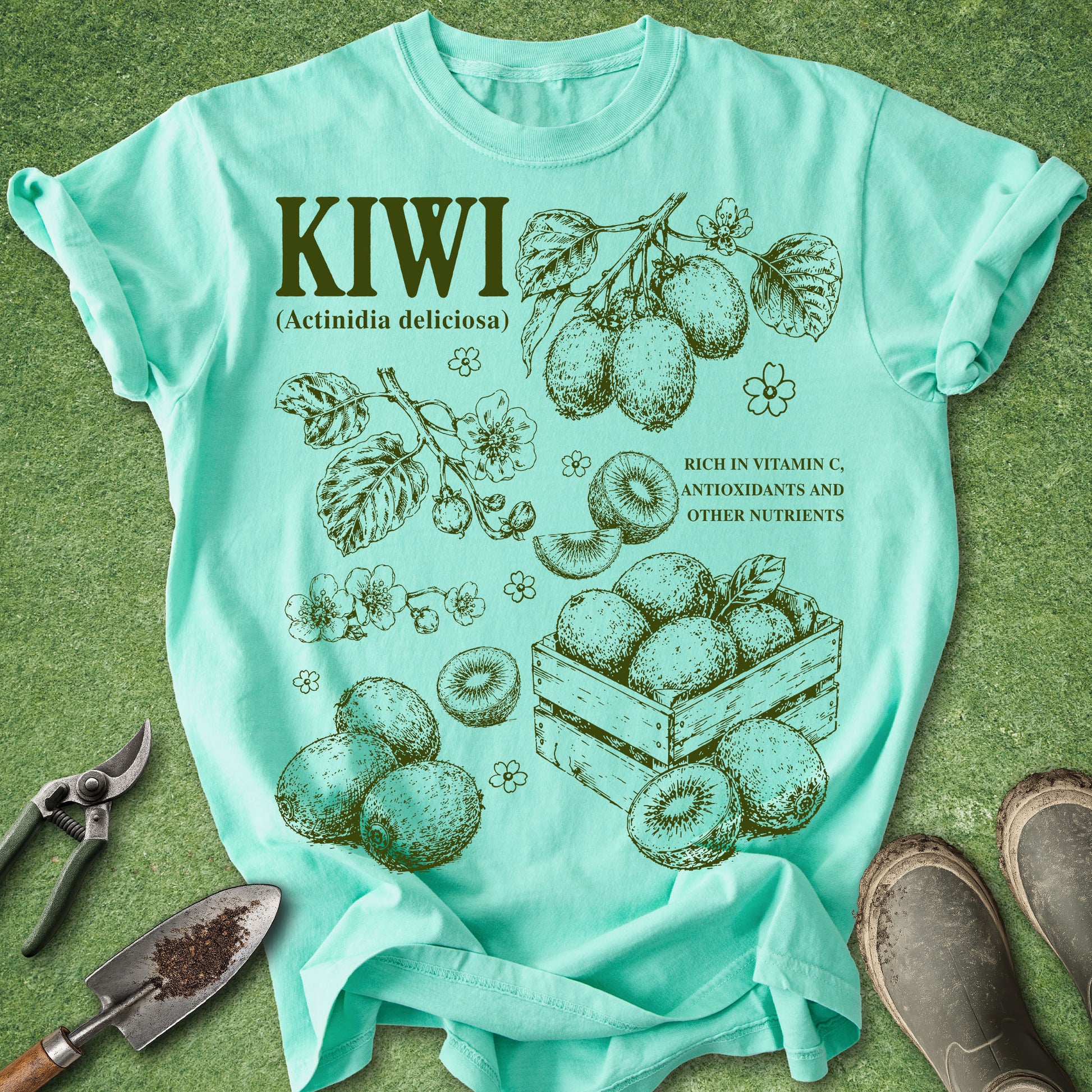Mint green t-shirt with kiwi illustration and text on a grass background
