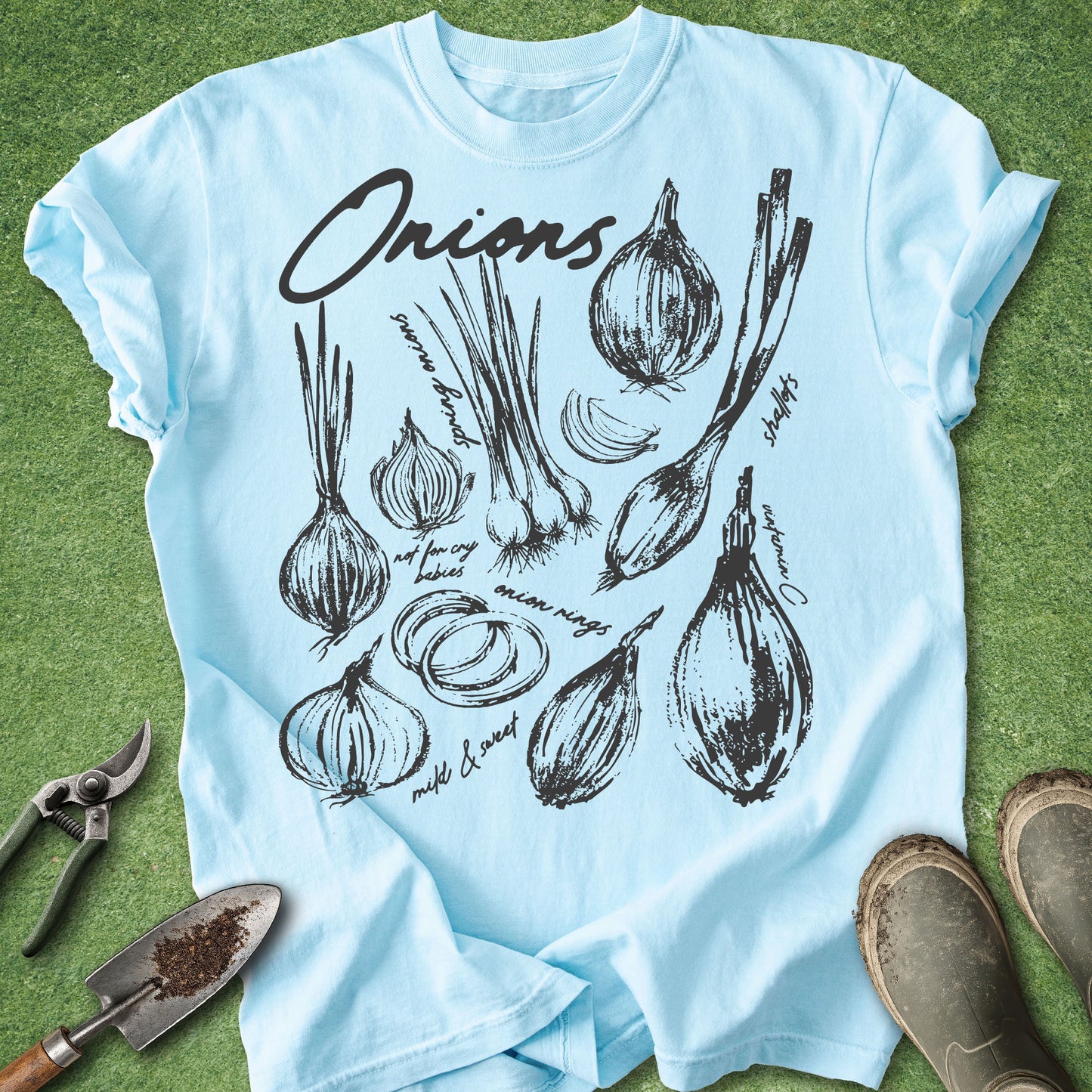 Light blue t-shirt with onion illustrations on a green grass background