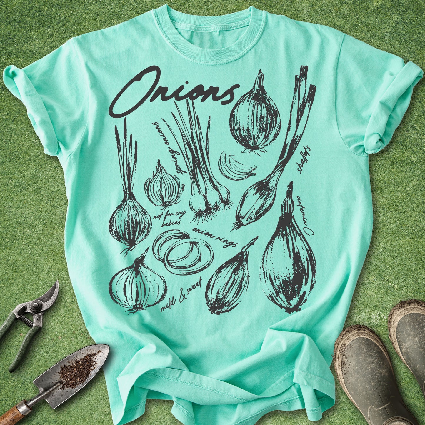 Mint green t-shirt with onion illustrations on a grass background