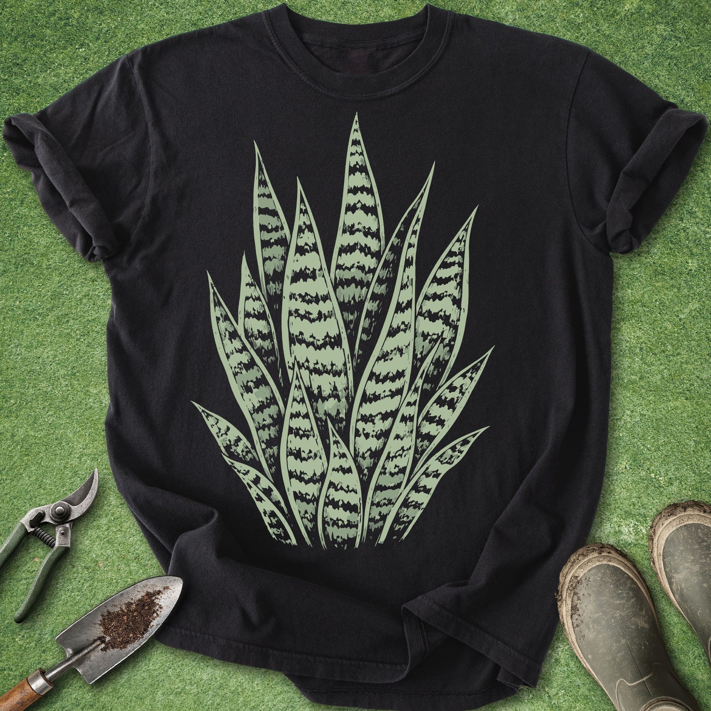 Black t-shirt with snake plant design on a green grass background