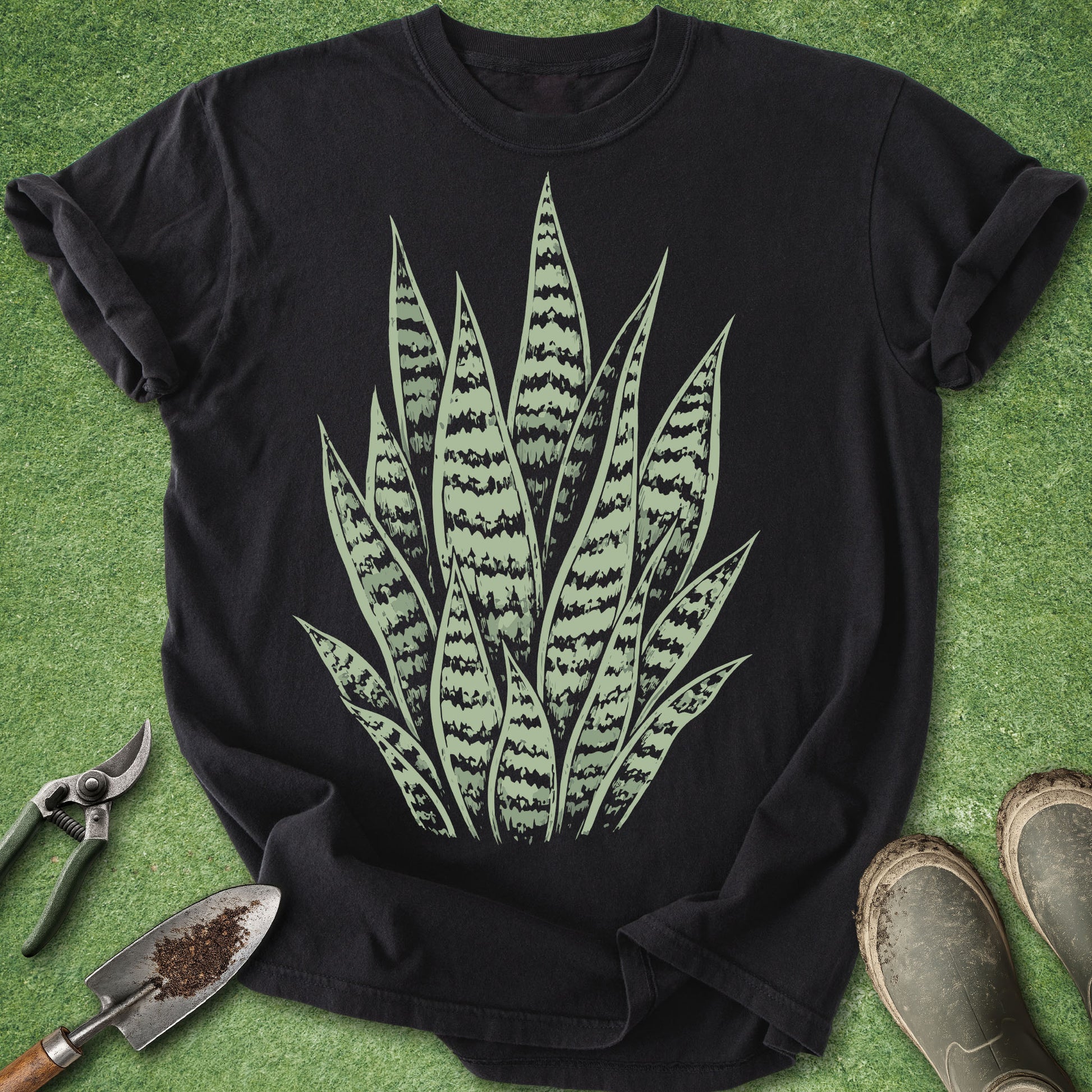 Black t-shirt with snake plant design on a green grass background