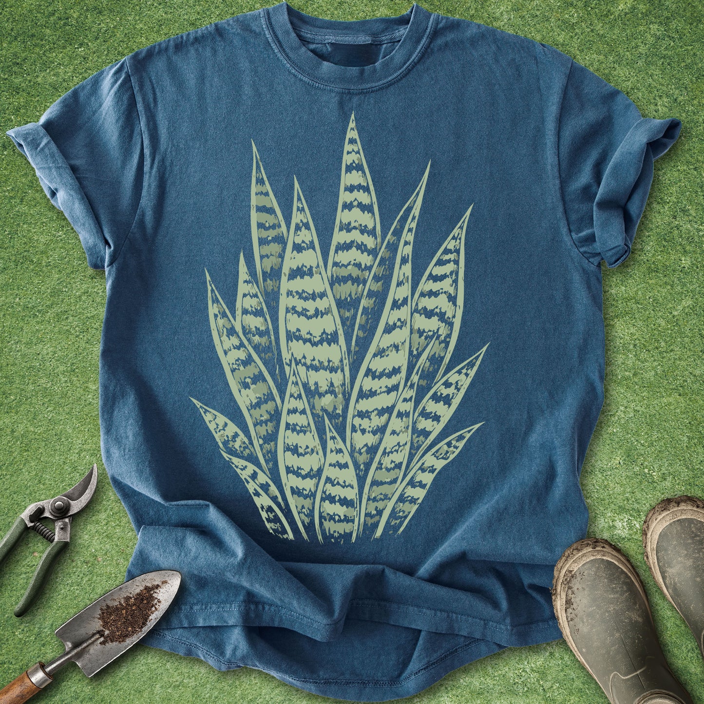 Blue t-shirt with green plant design on a grass background