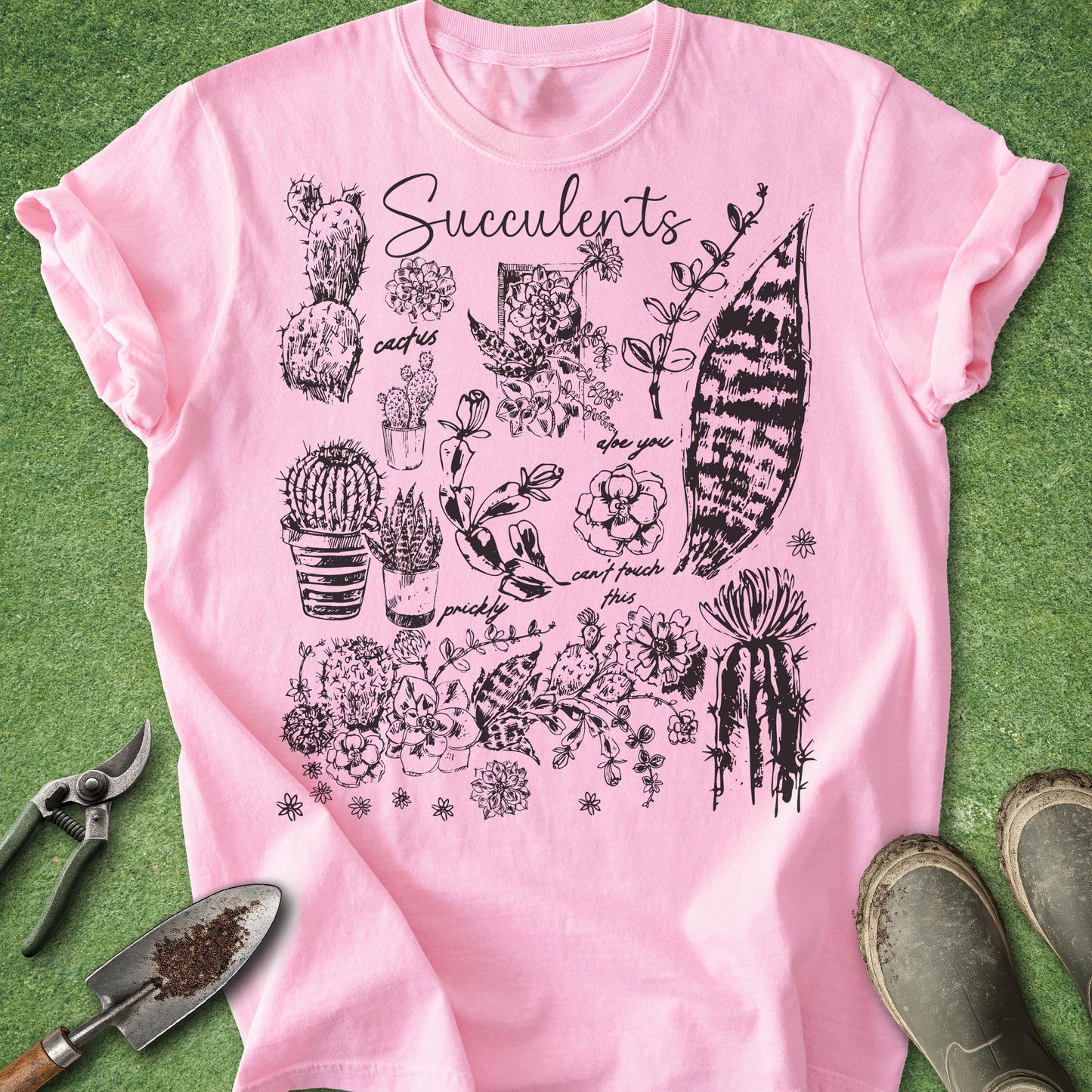 Pink t-shirt with succulent plant illustrations on a green grass background