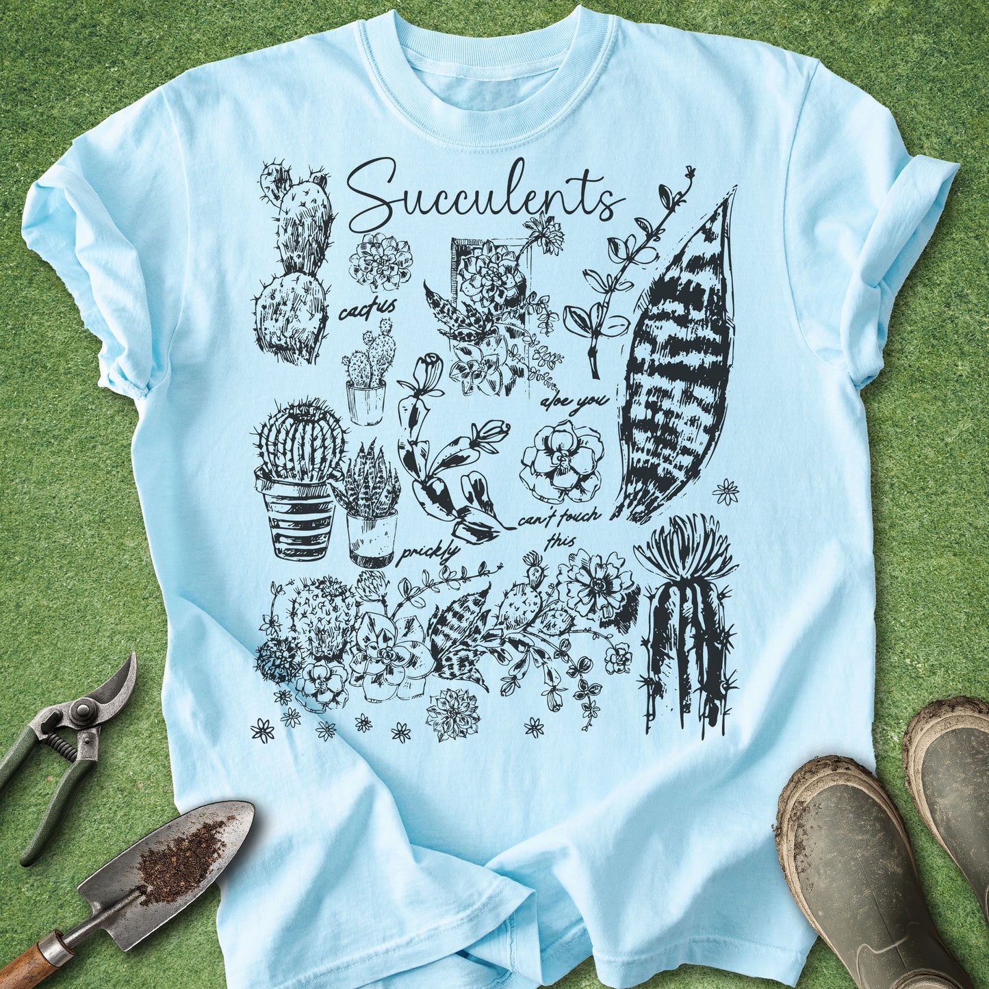 Light blue t-shirt with succulent plant illustrations on a grass background
