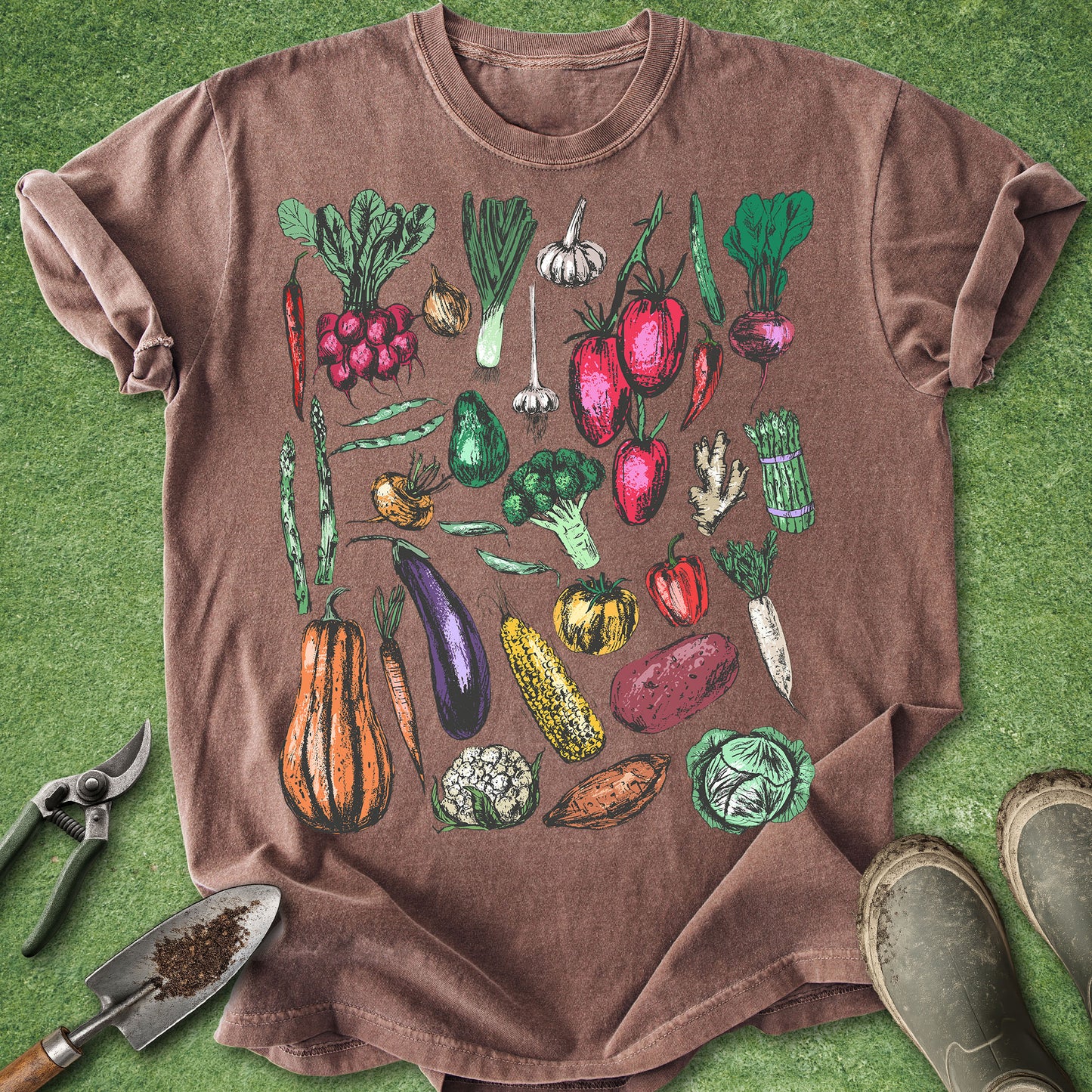Brown t-shirt with colorful vegetable illustrations on a green grass background