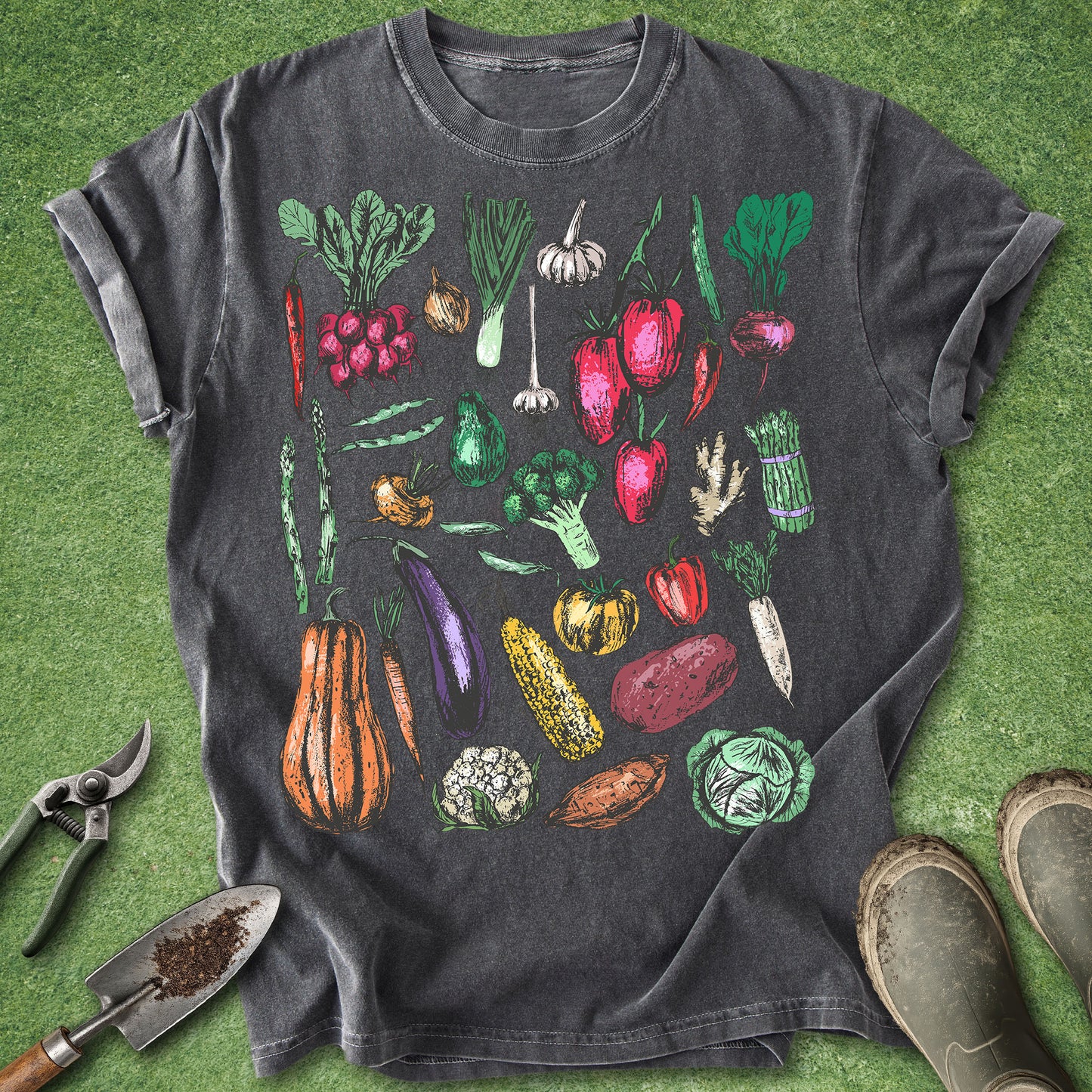 Dark gray t-shirt with colorful vegetable illustrations on a green grass background
