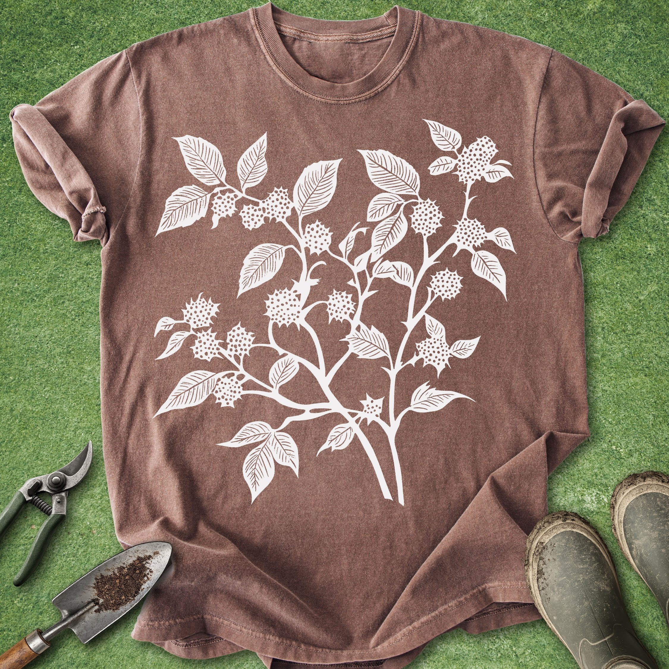 Brown t-shirt with white floral design on a green grass background