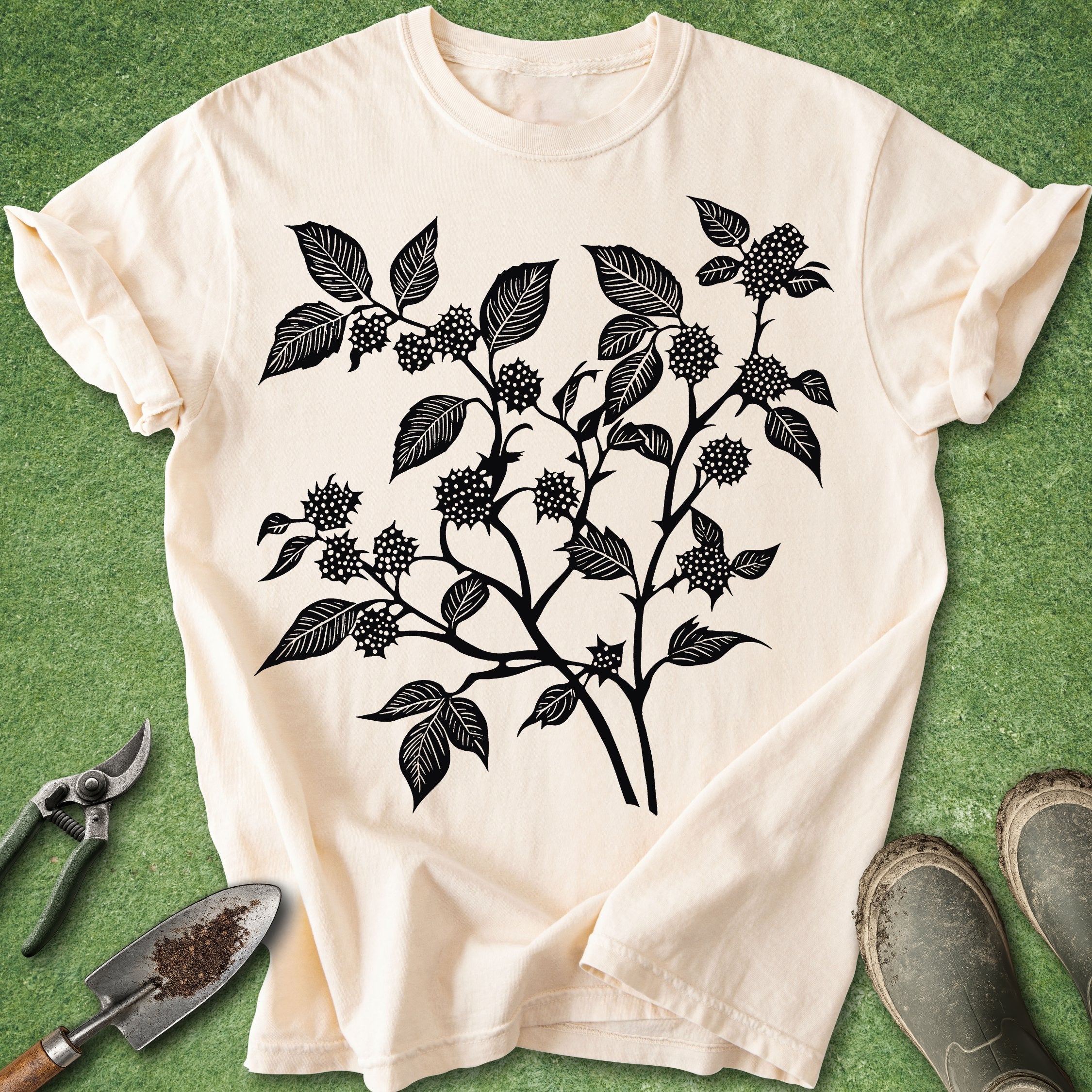 White t-shirt with black leaf design on a green background