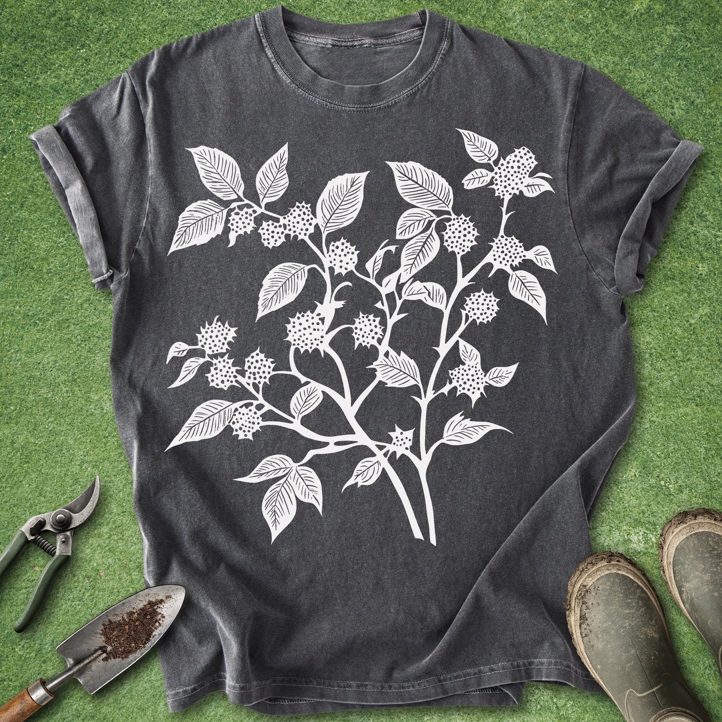 Dark gray t-shirt with white floral design on a green grass background