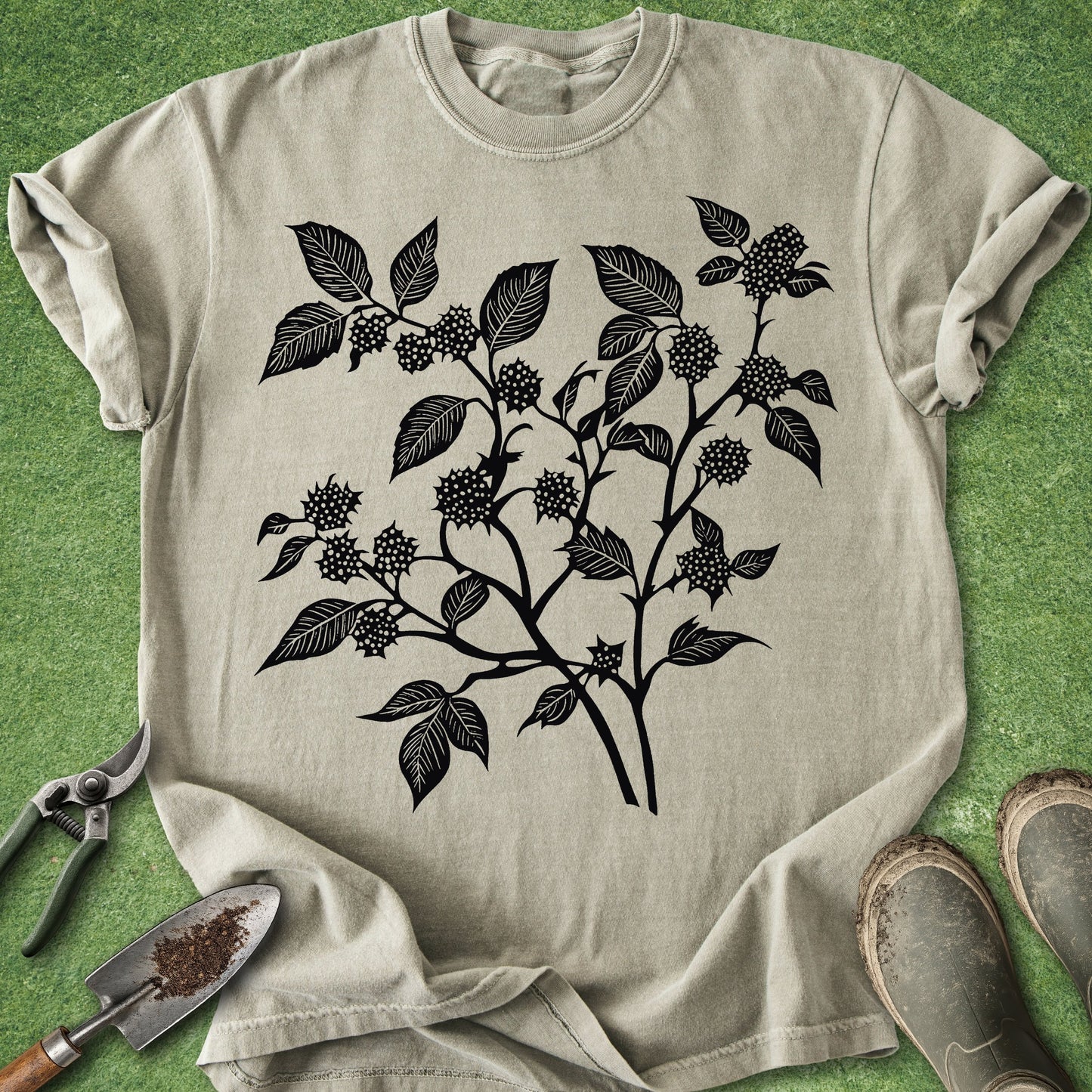 Beige t-shirt with black leaf and berry design on a green background