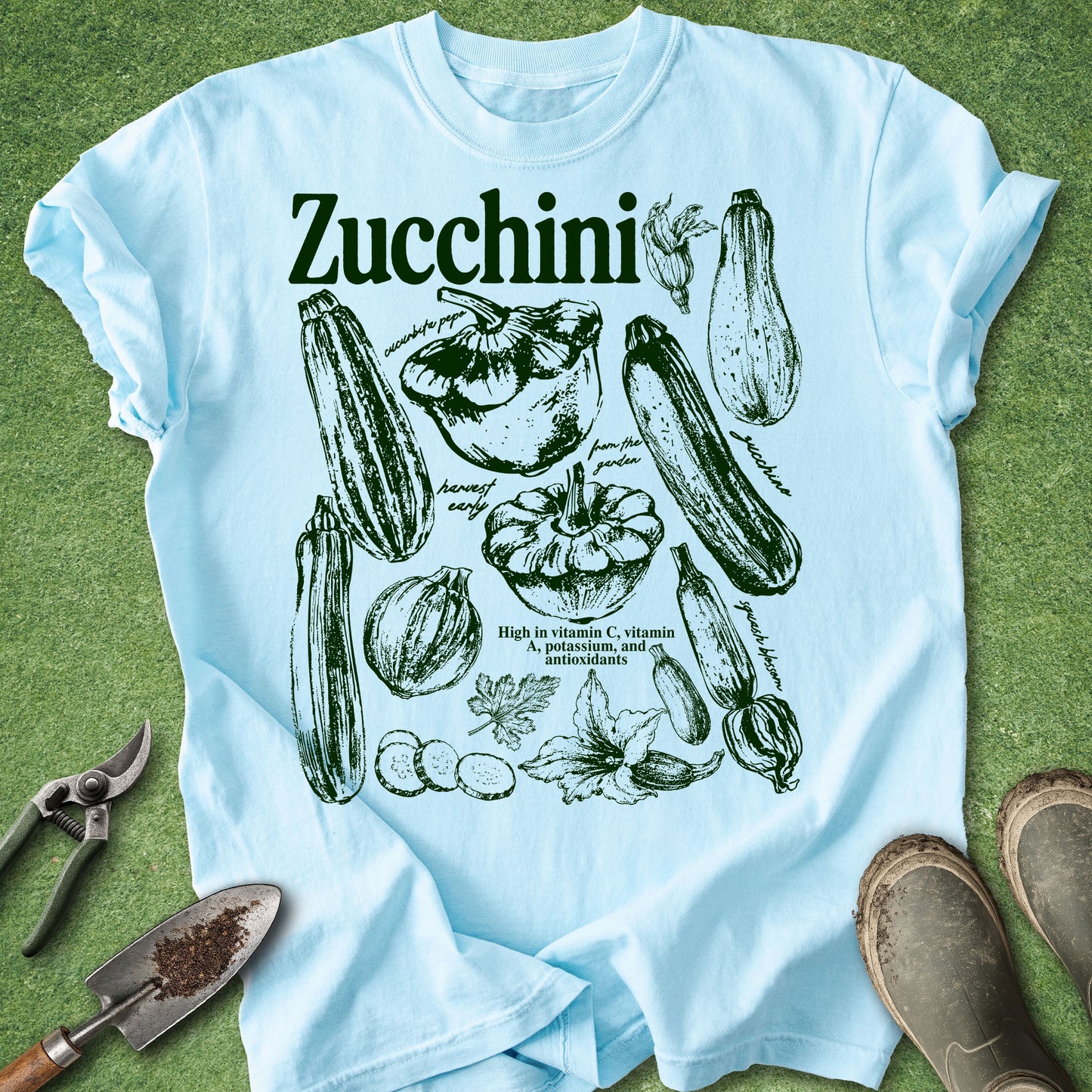 Light blue t-shirt with zucchini illustrations on a green background