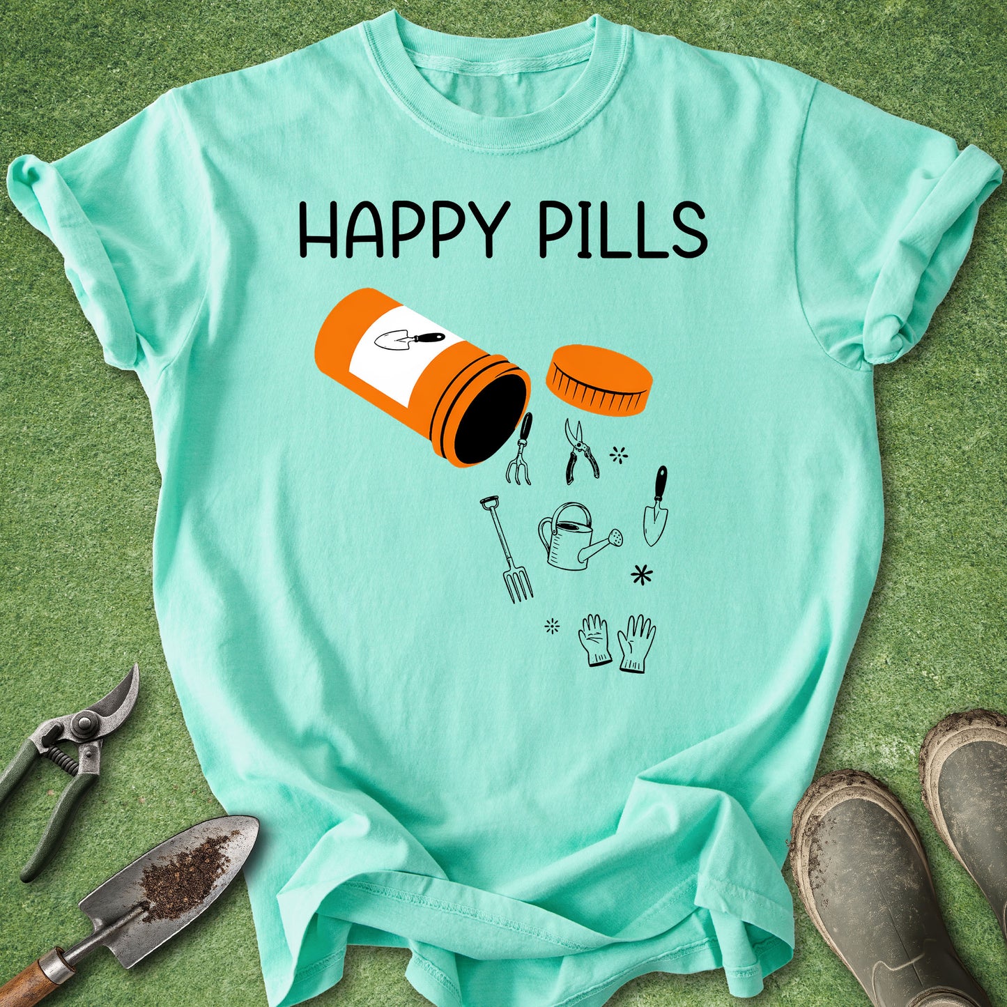 Light blue t-shirt with 'Happy Pills' graphic and gardening tools on a green background