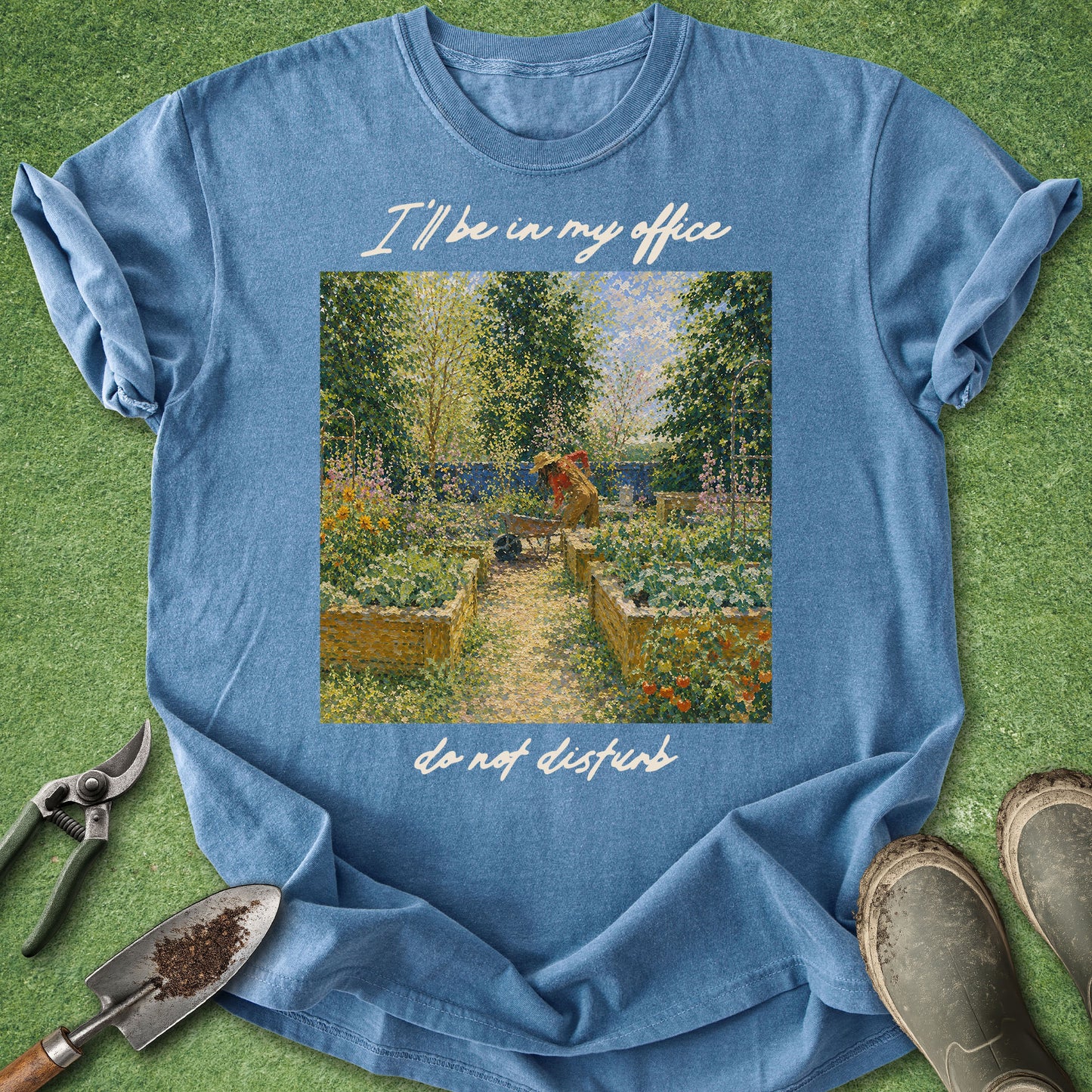 Blue t-shirt with garden graphic and text on a grass background