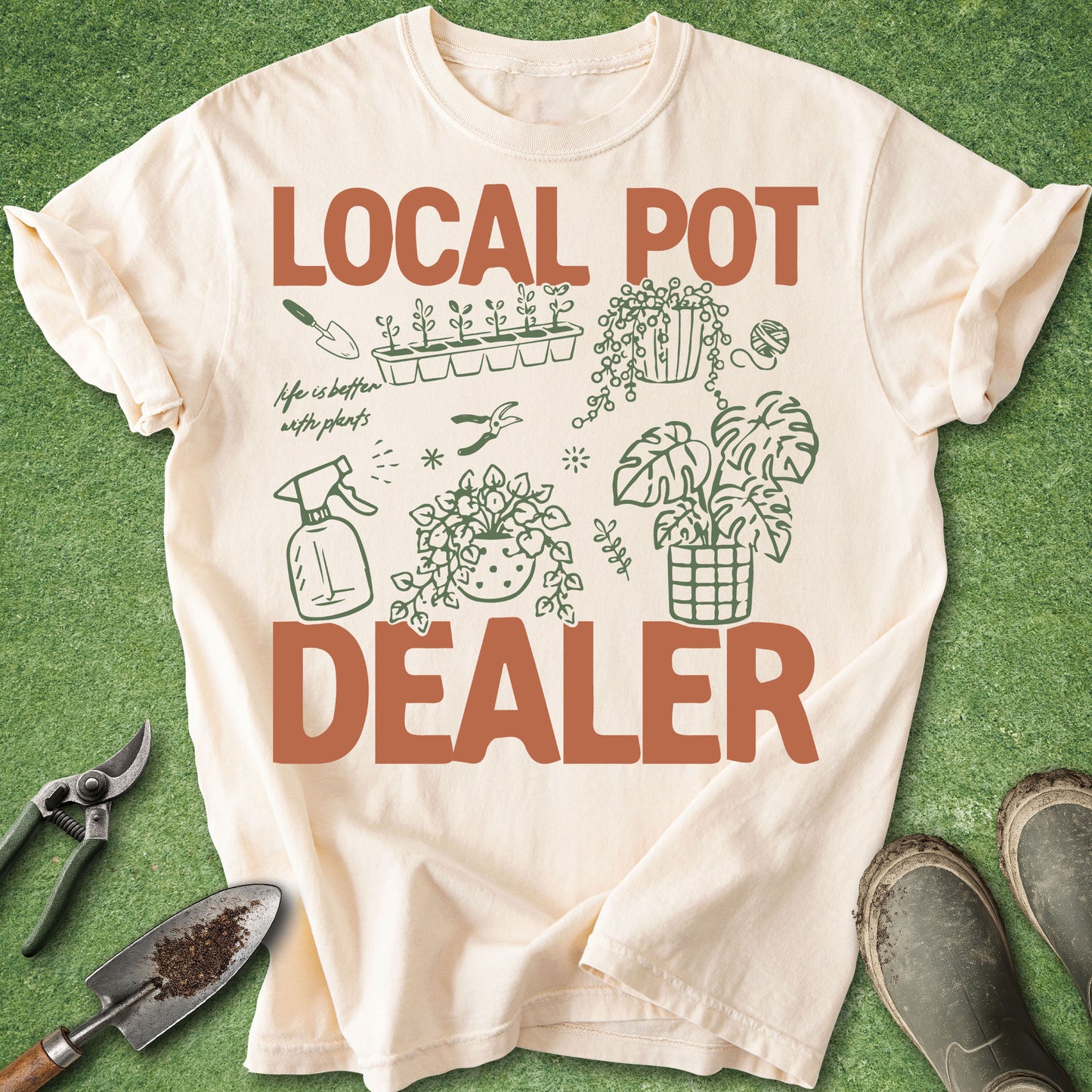 Ivory Comfort Colors t-shirt featuring the phrase "Local Pot Dealer" with illustrated houseplants, propagation tray, watering spray bottle, pruning shears, hanging plant, monstera, and indoor gardening accessories.