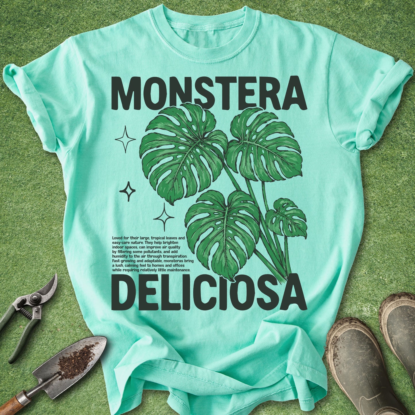 Mint green t-shirt with monstera deliciosa design on a grass background