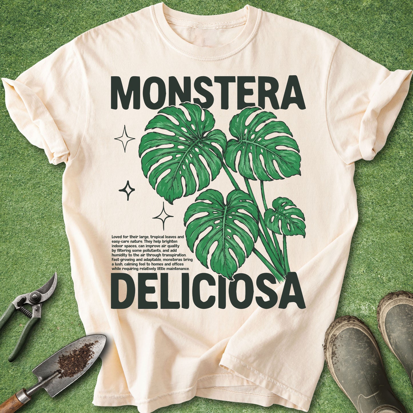 Ivory Comfort Colors t-shirt featuring a bold Monstera Deliciosa botanical design with vibrant green split leaves and vintage-inspired typography, perfect for plant lovers and houseplant enthusiasts.