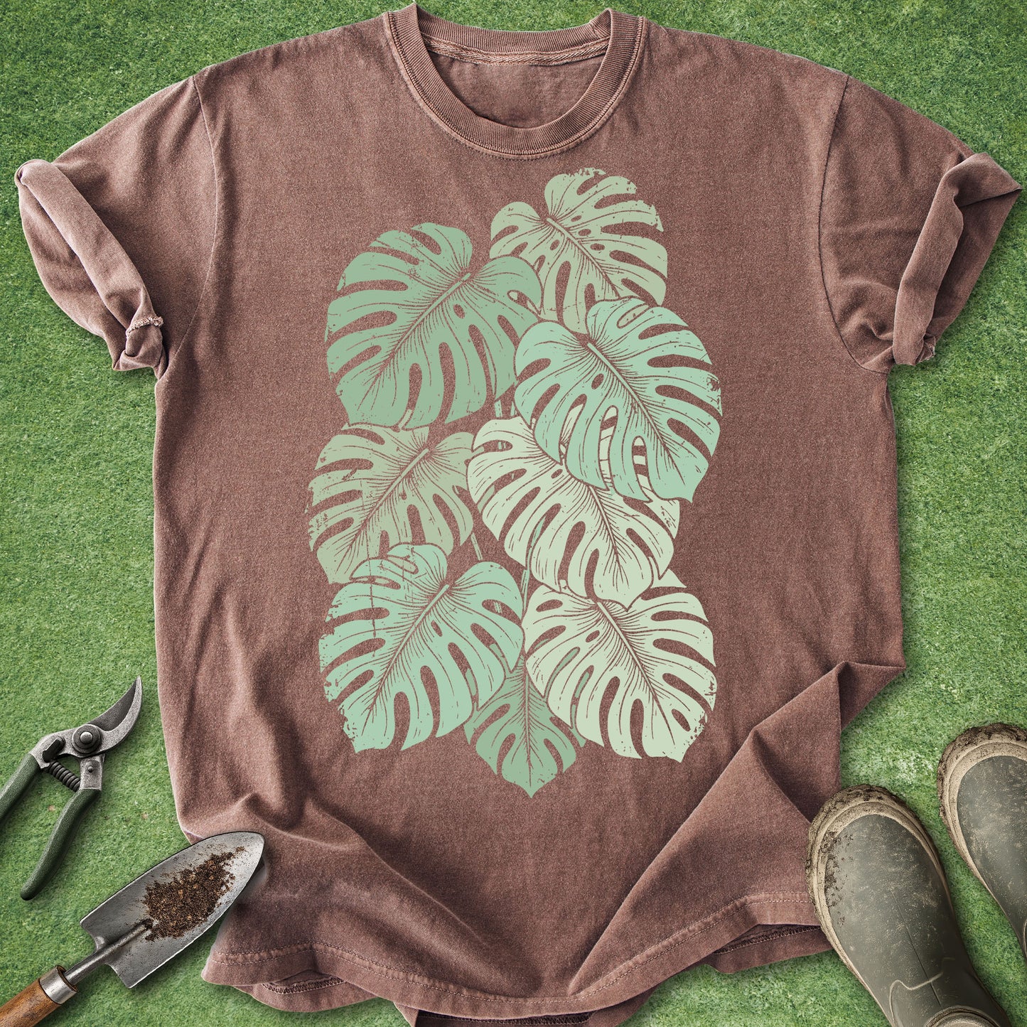 Brown t-shirt with green leaf design on a grass background