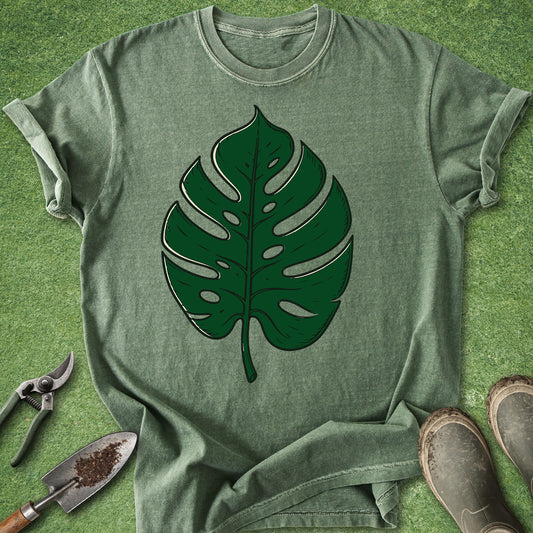 Green t-shirt with a leaf design on a grassy background