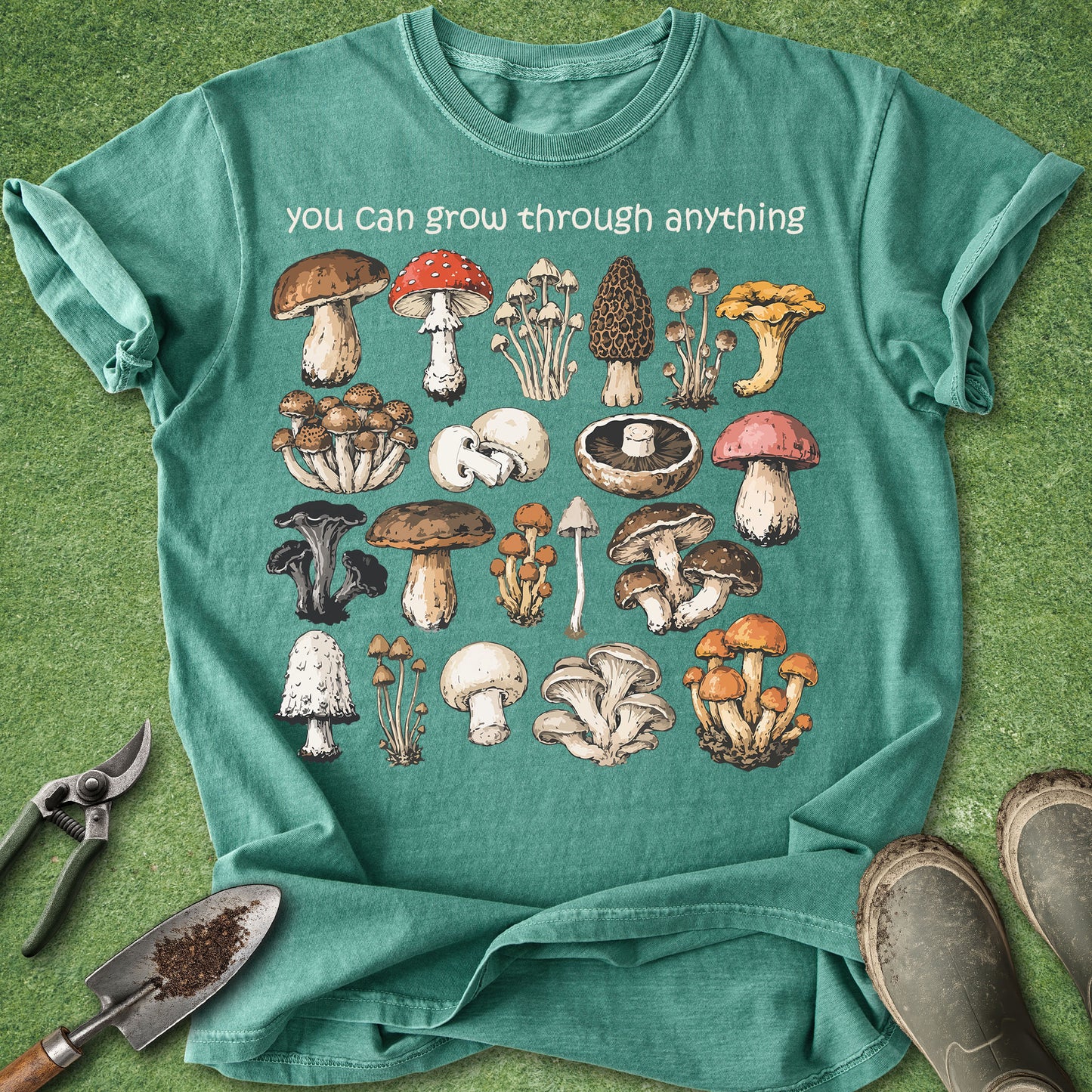 Teal t-shirt with mushroom illustrations and text on a green background