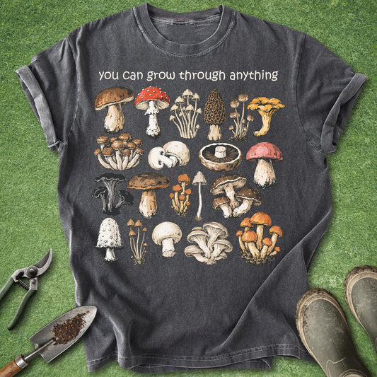 Pepper Comfort Colors t-shirt featuring the phrase "You Can Grow Through Anything" above a vintage botanical collection of colorful wild mushroom illustrations in a woodland field guide style.