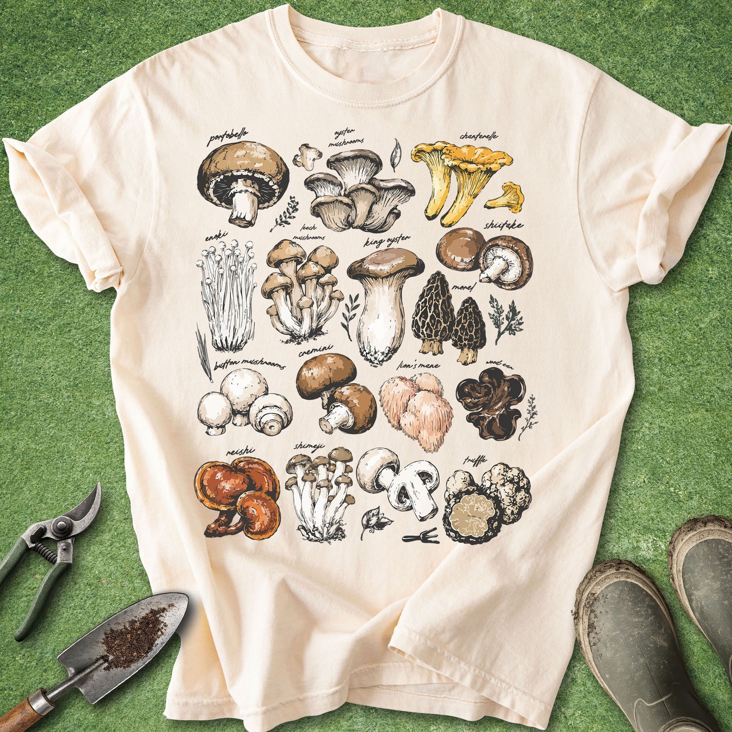 Ivory Comfort Colors t-shirt featuring a vintage botanical chart of assorted mushroom species including chanterelle, oyster, shiitake, lion's mane, morel, reishi, truffle, and button mushrooms illustrated in a natural history field guide style.