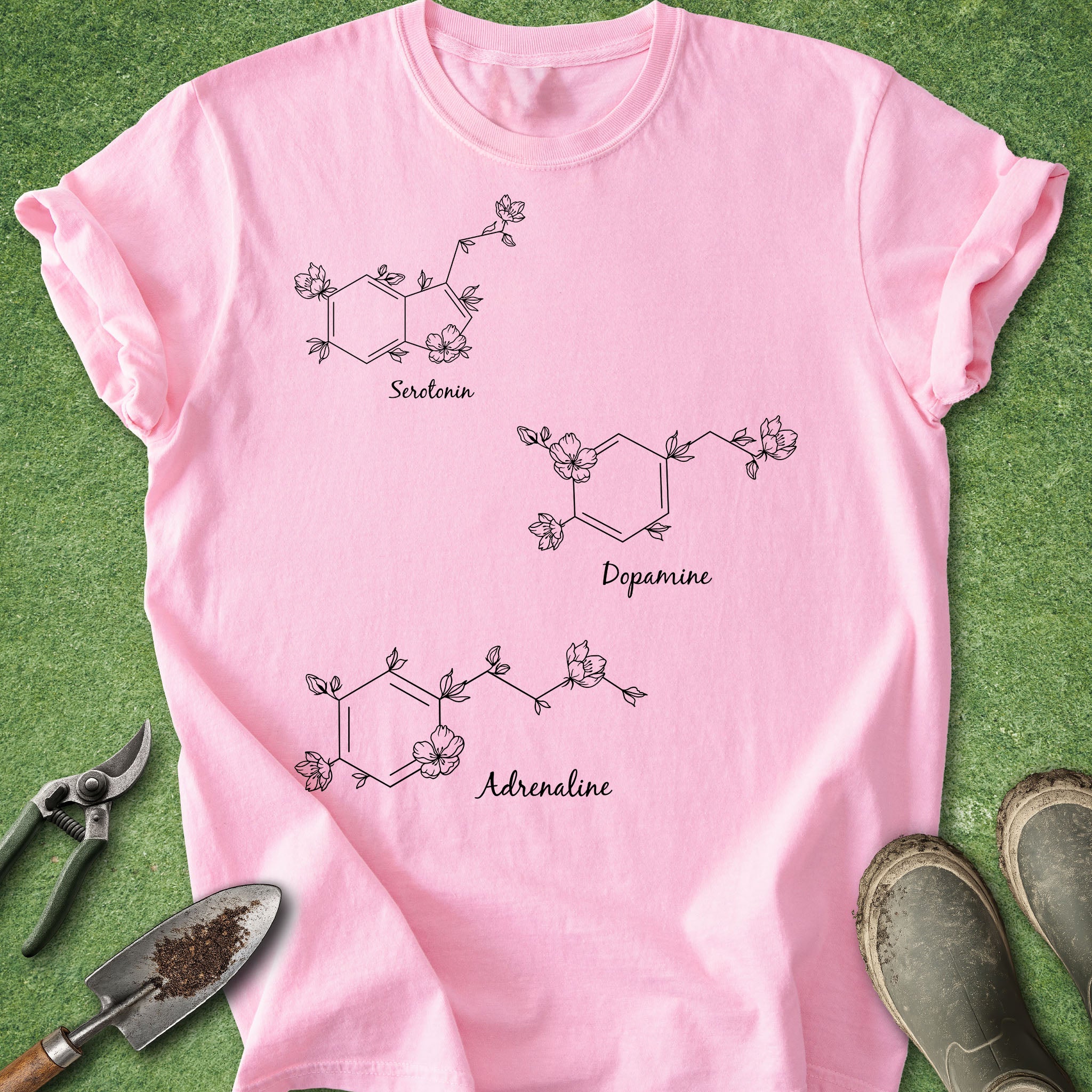 Pink t-shirt with chemical molecule designs on a green grass background